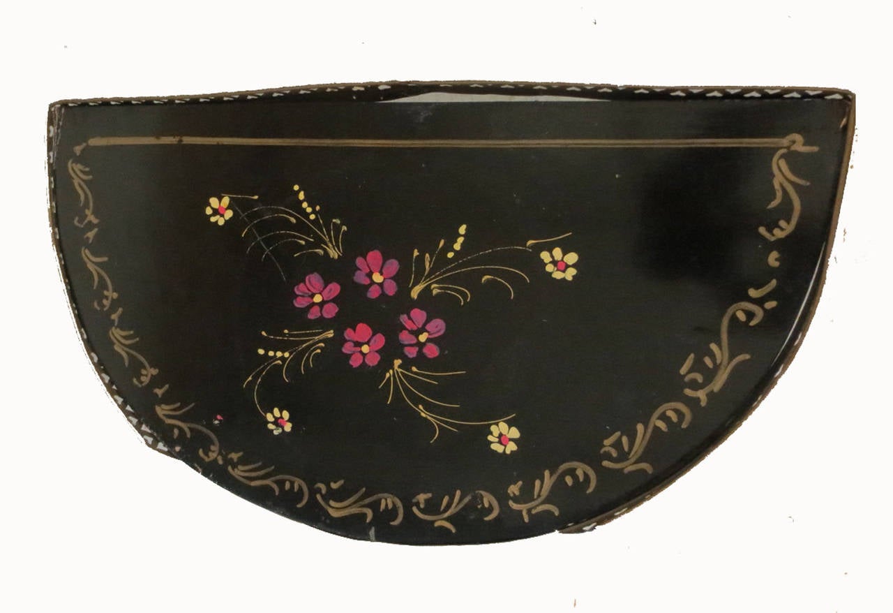 Pair of black with floral hand painted demilune side tables with reticulated brass gallery.
