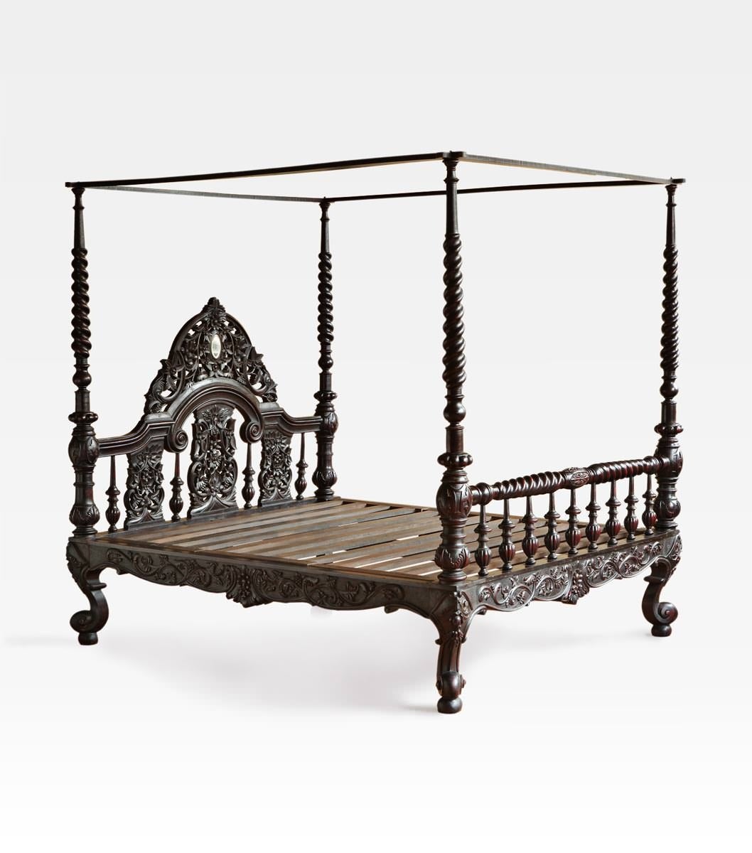 Indo-Portuguese bed. Made of precious rosewood with beautiful red shades. The structure and the headboard are hand-carved with elegant floral motifs, like the beautiful four spiral turned posts and the round legs.
The canopy is removable.