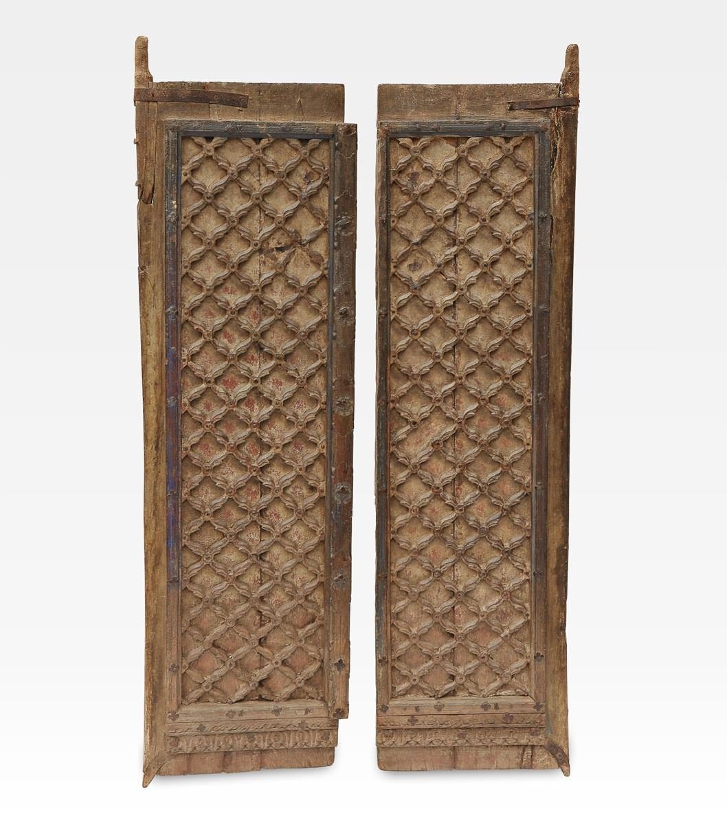 Ancient indian double door, from Mughal period. Made of wood, decorated with a carved grid. On the base there is a beautiful frieze with traditional indian motifs. On the frame are visible traces of natural blu dye.