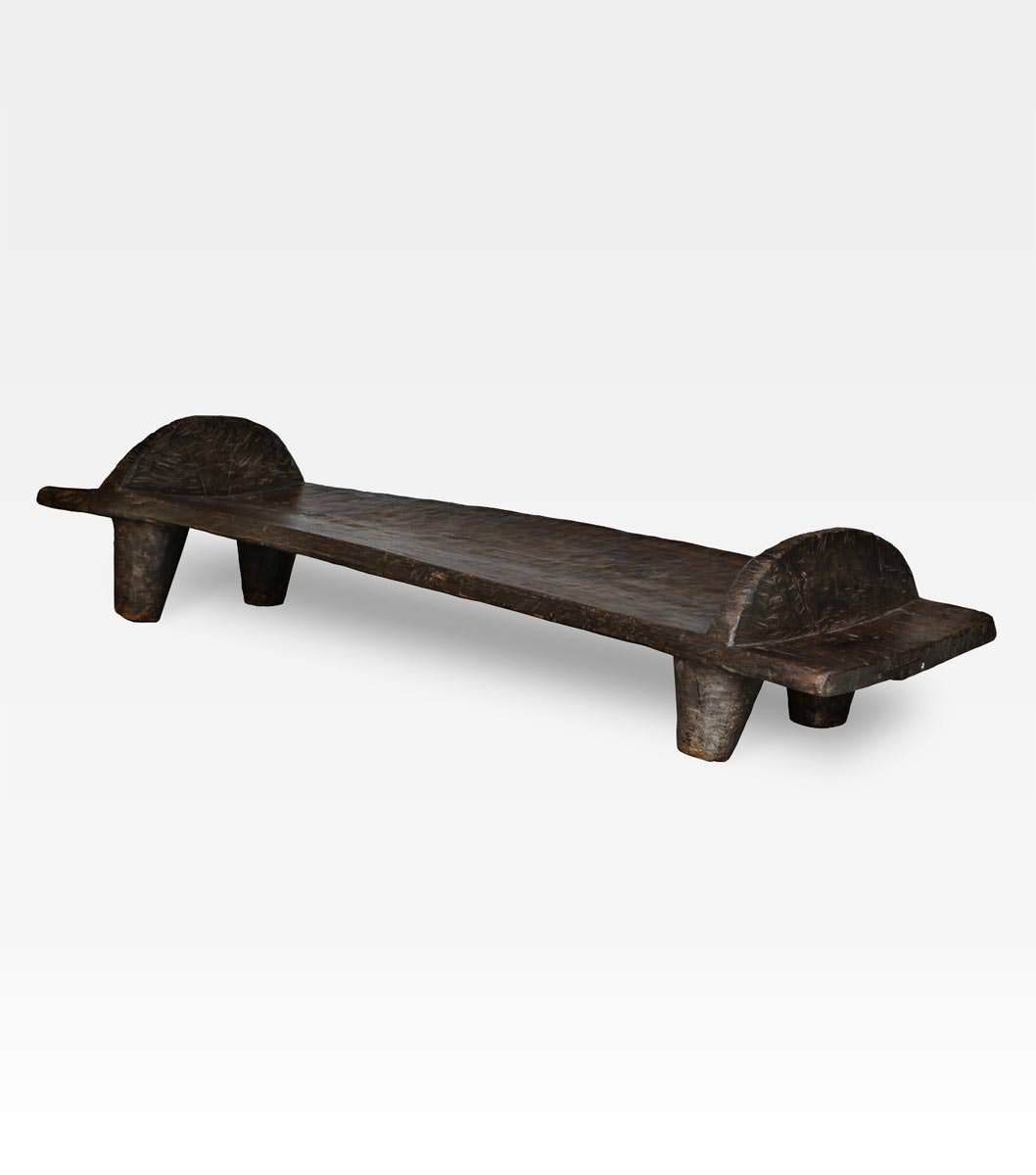 This beautiful bench was originally a bed used from Naga people. Carved from a teak bole, the dark color show the antiquity of wood. Today is perfect as a table o as a bench