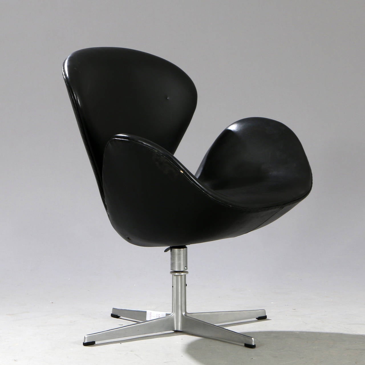 Arne Jacobsen The Swan. Easy chair with profiled swivel frame and aluminum base. swivel and tilt. Upholstered with black vinyl.