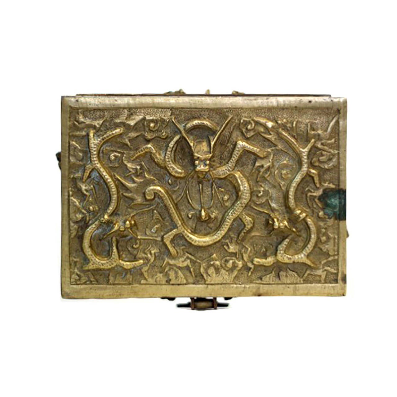 An early 20th century brass box with a striking design of nine flying dragons, each in relief with four outstretched claws, horns, whiskers and sinuous bodies. Circa 1920. 

The lid of the rectangular brass box has three dragons including one