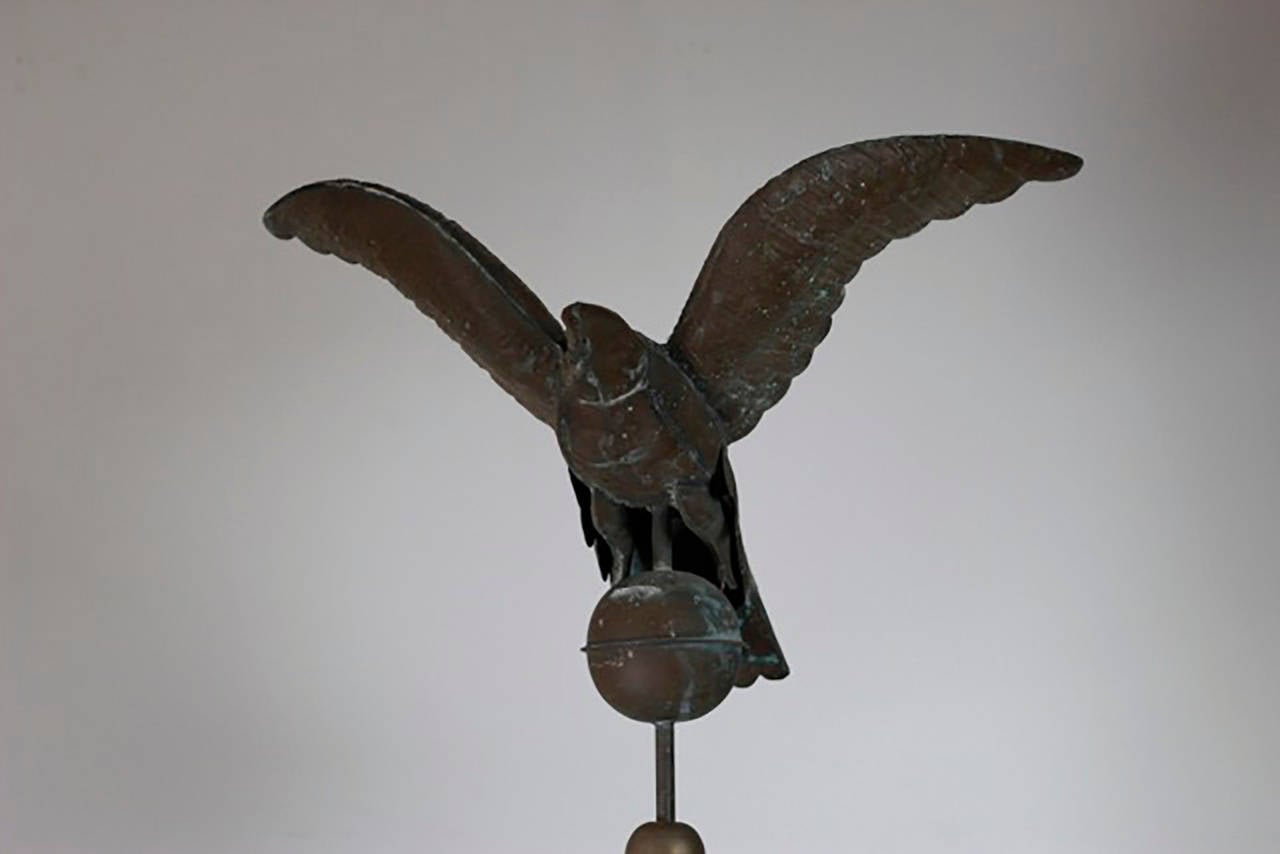 Monumental verdigris weathervane with fully spread eagle and bronze directional sign. The weathervane is mounted on a new, custom steel stand. 
The weathevane is in excellent condition. The eagle's beak has a slight bend denoted in the pictures.