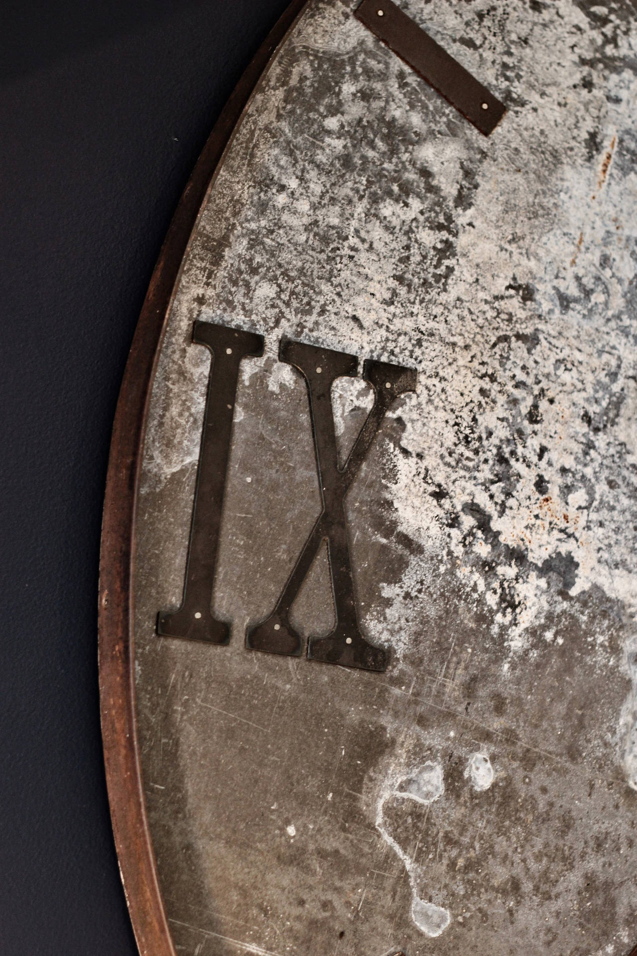 Zinc oxidized wooden clock with cast iron surround and cast iron hands and numbers.