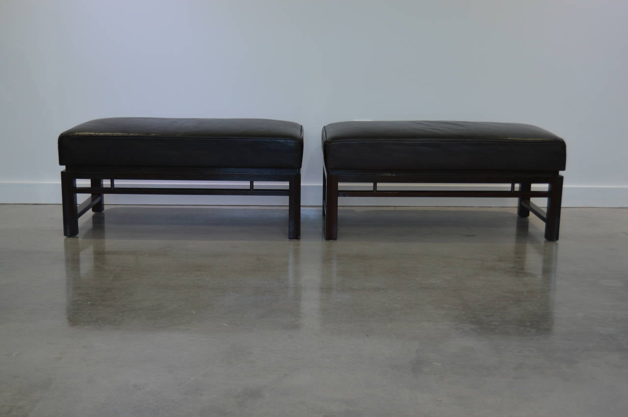 This stylish pair of benches were designed by Edward Wormley for Dunbar in the 1940s and they retain their original dark brown leather which works works beautifully with the mahogany wood frame.

The stretchers are detailed with metal dowels in an