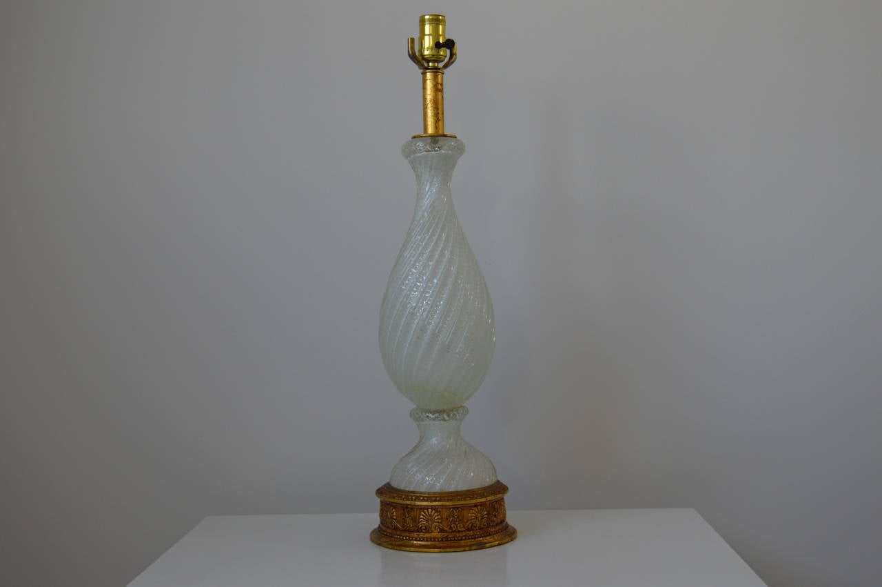 This pair of white Murano glass table lamps with a swirl/twist vase form and an antique gold finish base were created by Barovier & Toso in the 1950s. 

Please feel free to contact us directly for a shipping quote, or other questions and