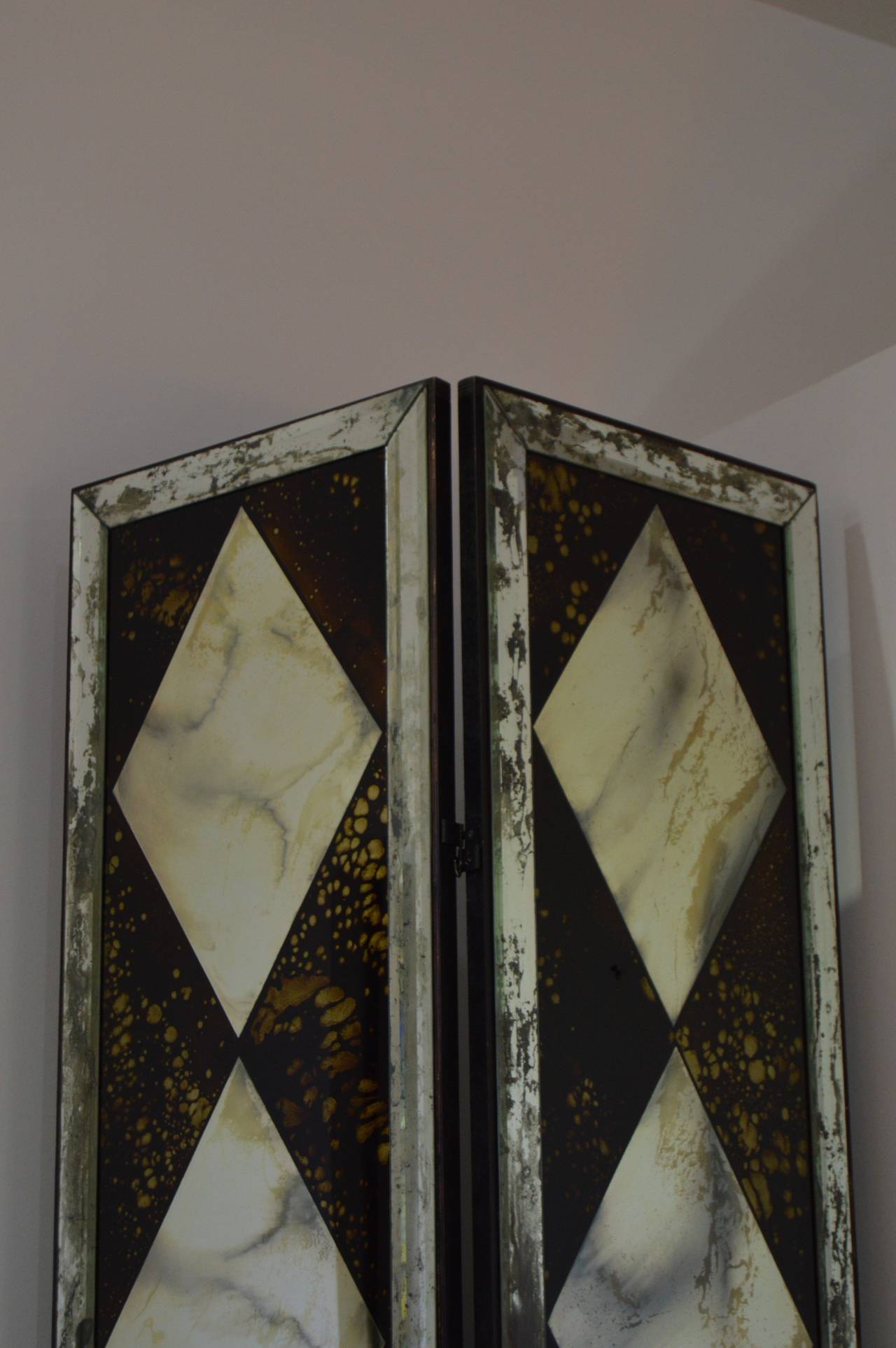 This beautiful pair of mirrored double-hinged folding screens definitely took there inspiration from the iconic style and taste maker Dorothy Draper. 

They command a presence with their black painted frame on which a  2