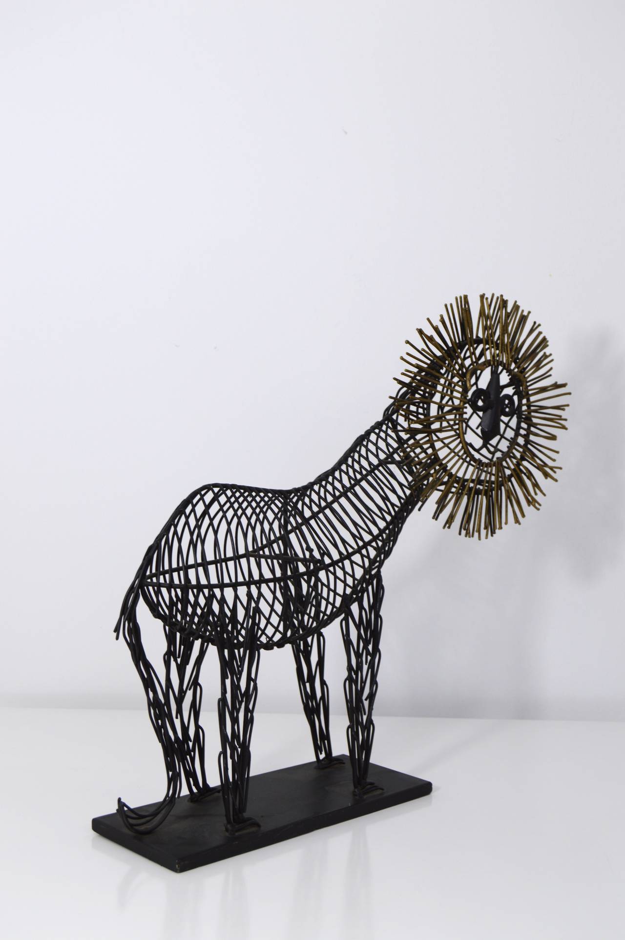 This sculpture of a lion definitely takes his inspiration from pieces created by the iconic designer C. Jere.  The body of the piece is made of steel which has been painted black and the mane has been painted in gold.