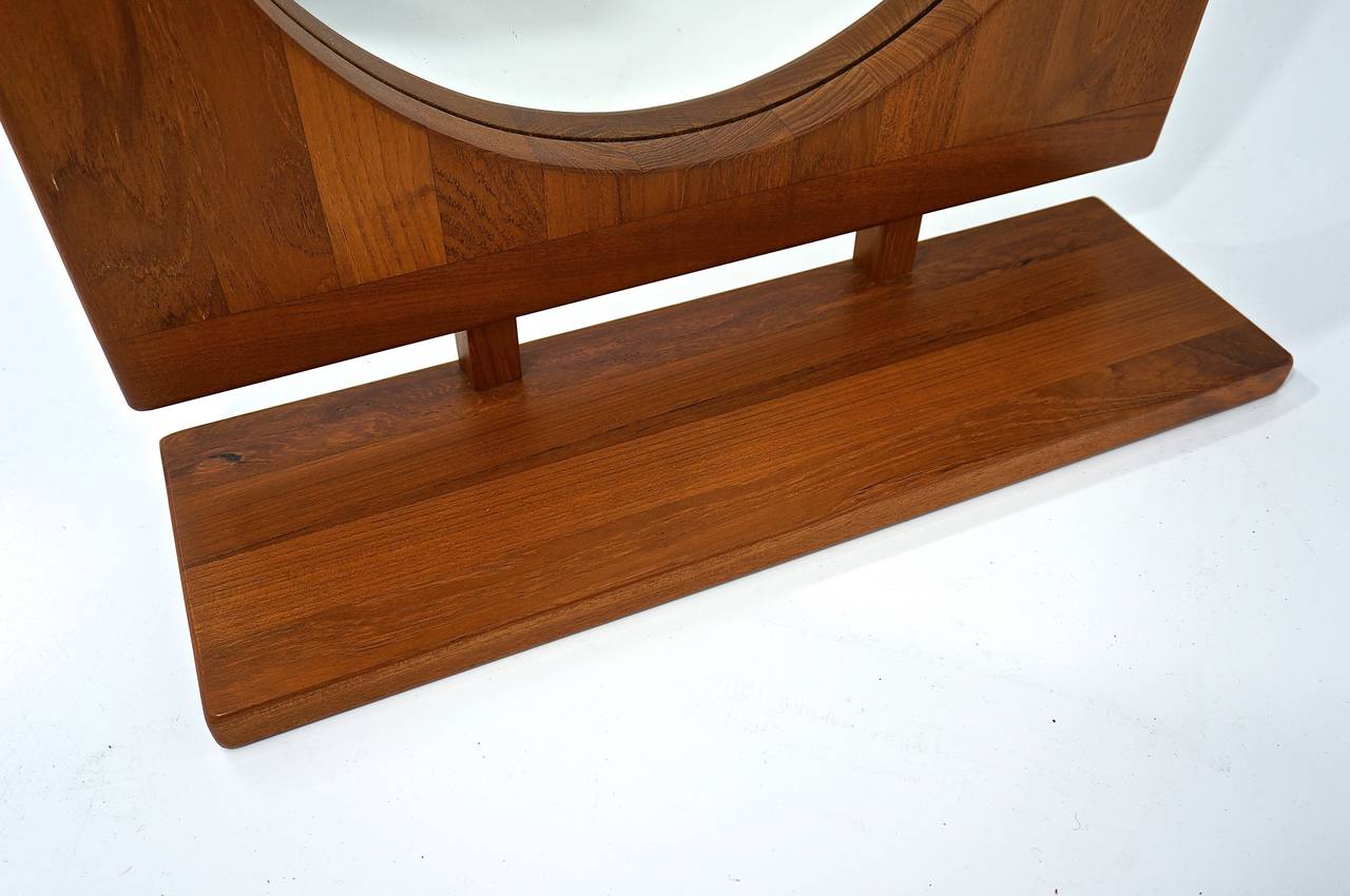 This Mid-Century table or wall-mount mirror with shelf was made by the firm of Pedersen & Hansen of Denmark in the 1960s and is made of Teak wood.

The mirror style is identified on the reverse-side with the P&H label, the Pedersen and Hanson VIGY