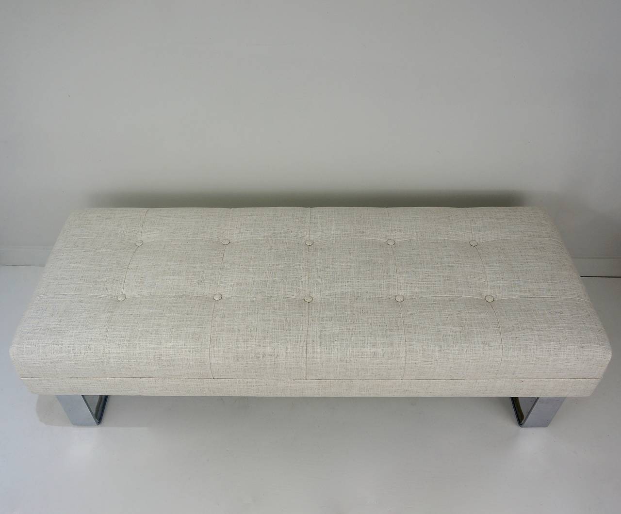 This incredible bench was designed in the 1970s by Milo Baughman for the Thayer Coggin Furnniture Company. It has recently been reupholstered with a button-tufted top in a cream-colored, blended-linen fabric. 

This bench would be the perfect size