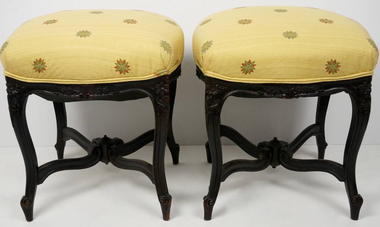 This wonderful pair of Louis XV revival stools were created in 1880. They are hand-carved walnut with upholstered seats. 

The fabric is a woven cotton-blend with a diamond-pattern and stylized flowers.

Please feel free to contact us for a