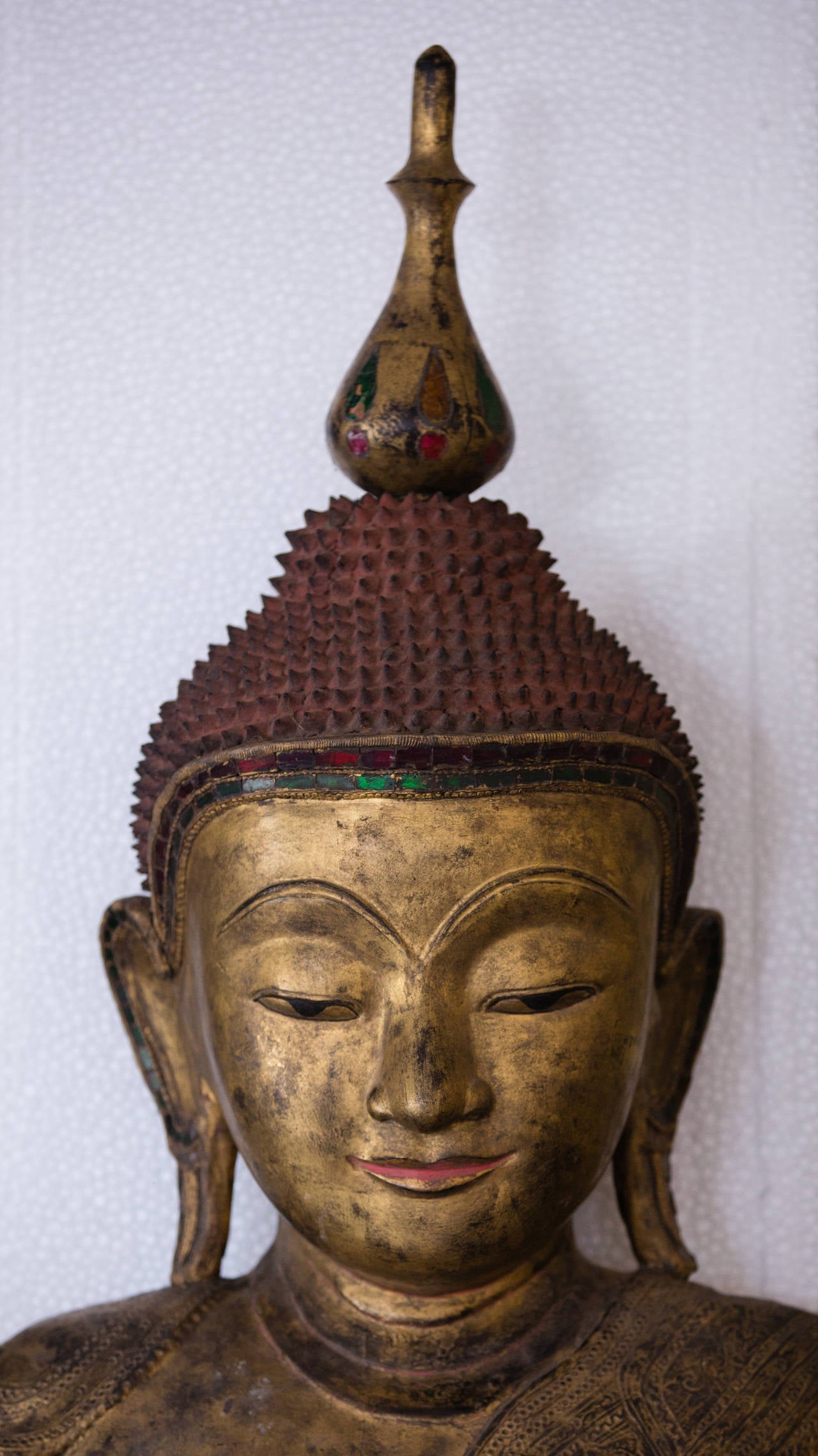 Burma, a monumental seated Buddha, 67” high and 43” wide, late 19th century. 

The monumental seated effigy of the Buddha in Shan style posed in Dhyanasana with attached praying attendants and carved of gold gilded dry lacquer over wood seated atop