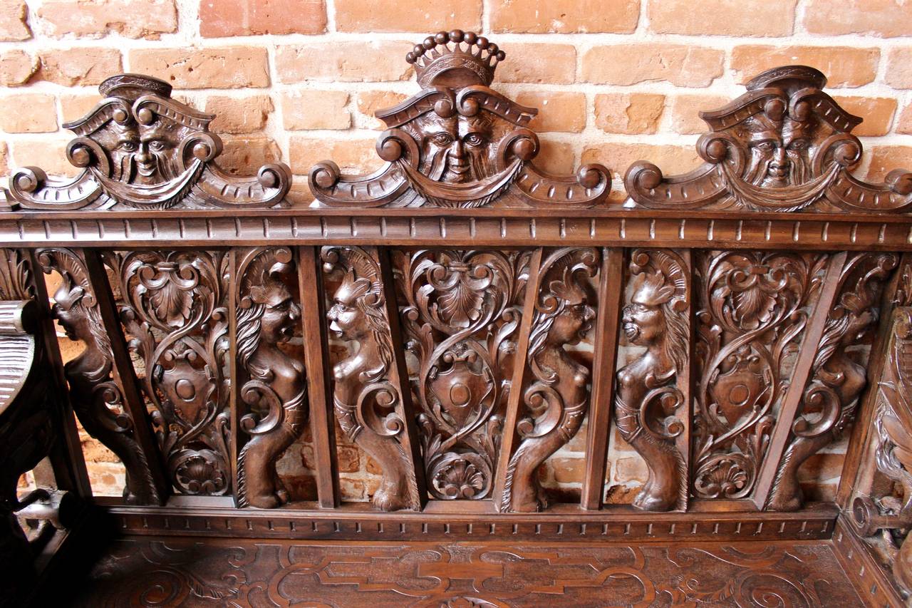 This hall bench is made in the Italian style.  The bench features ornately done decorative carving on its seat, front, and sides. It is also finished on each side. Circa 1900s.