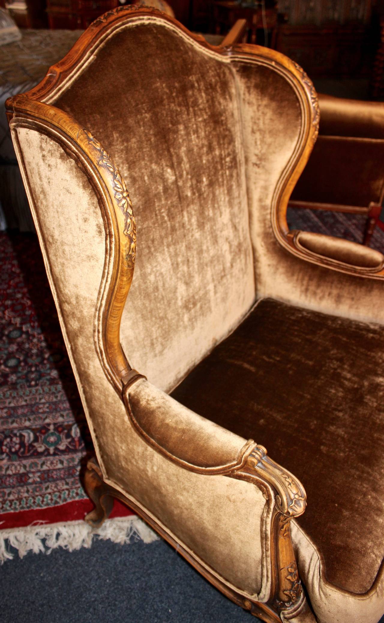 This French wingback armchair is made in the Louis XV style.  Features lush upholstery on all sides and ornate, hand-carved edges.  This piece makes a perfect accent for any living or office area.