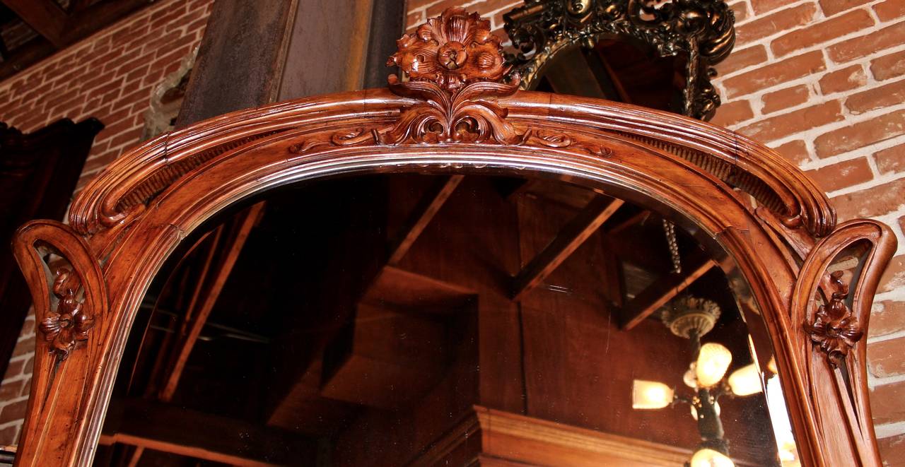 This French mirror and planter combination is made from walnut in the gorgeous Art Nouveau style.  It features a lower planter area and a large upper mirror.  There are two small shelves along the mirror's side for display.