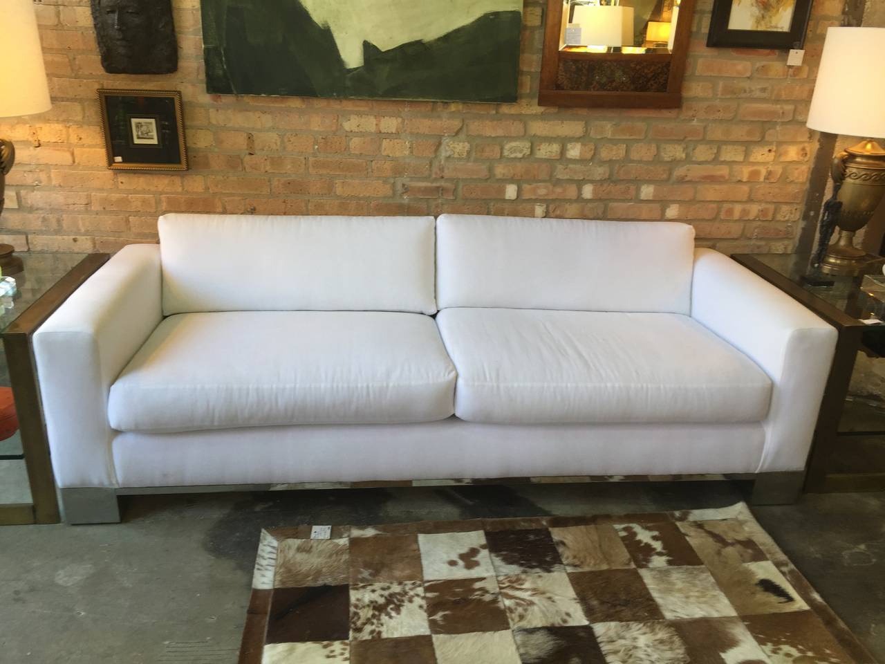 A Milo Baughman for Thayer Coggin chrome sofa. The two loose cushion back upon two loose cushion seat over a chrome plinth in excellent condition. Newly upholstered in white cotton upholstery, circa 1970.