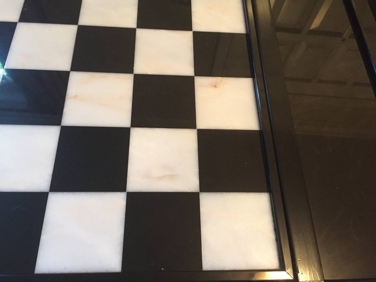 A mid-20th century custom games table having a veined marble top and high gloss black wood base. Grommeted marble slabs on either side with one hidden drawer for game pieces.