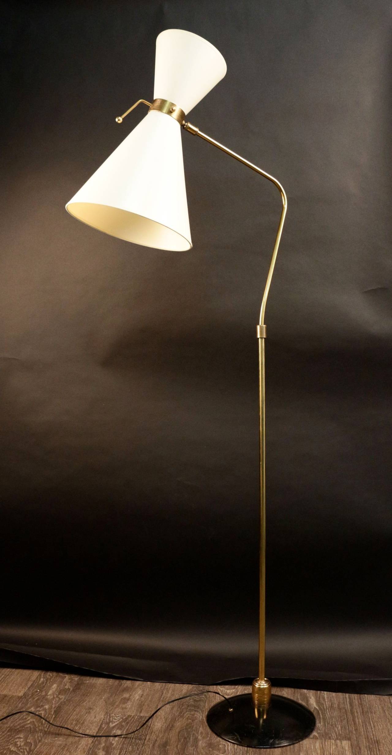 1950s floor lamp by Maison Lunel.
The double lampshade (two bulbs) is ball gear mounted. A handle allows freely orientation. 
Brass rod is also ball gear mounted and is ending with a round base in black lacquered metal.
Lampshade redone according