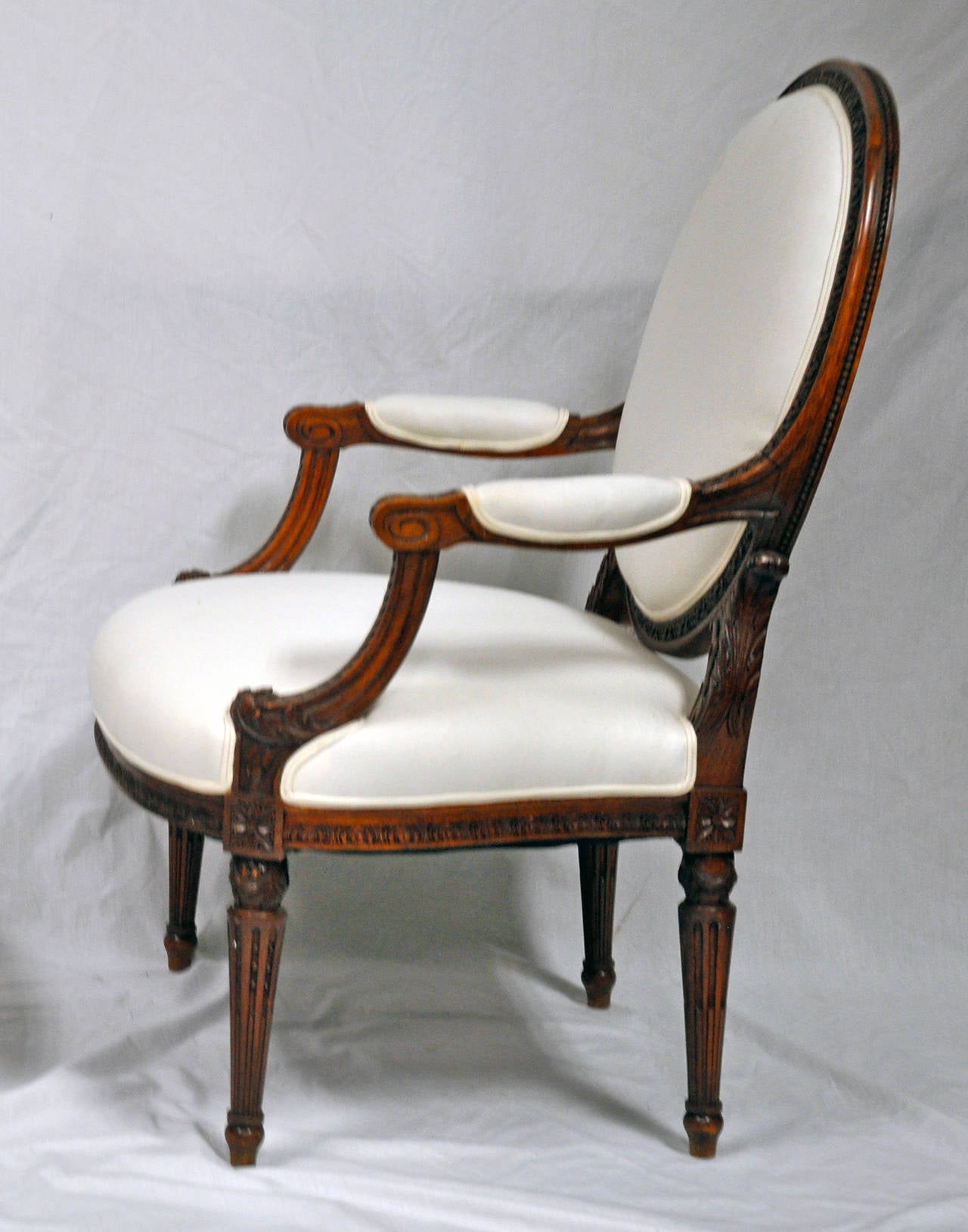 Pair of Classic Louis XVI styled fauteuil in great proportion and size for today with beautifully articulated carving in walnut. Newly upholstered in muslin. 

Established in 1979, Joyce Horn Antiques, ltd. continues its 36 year tradition of being