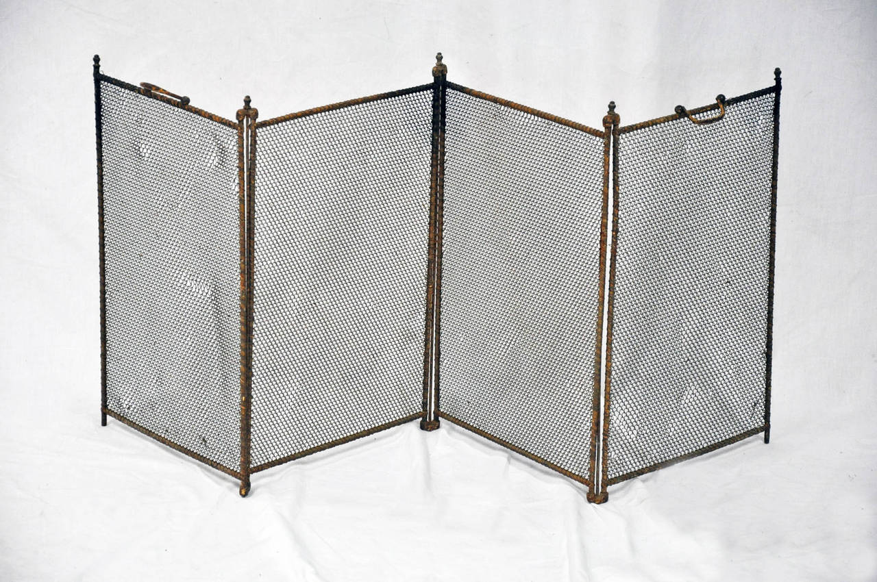 Understated four-panel wire mesh fire screen, old painted finish, small finials & intact handles. 

Established in 1979, Joyce Horn Antiques, ltd. continues its 36 year tradition of being a family owned and operated business specializing in hand