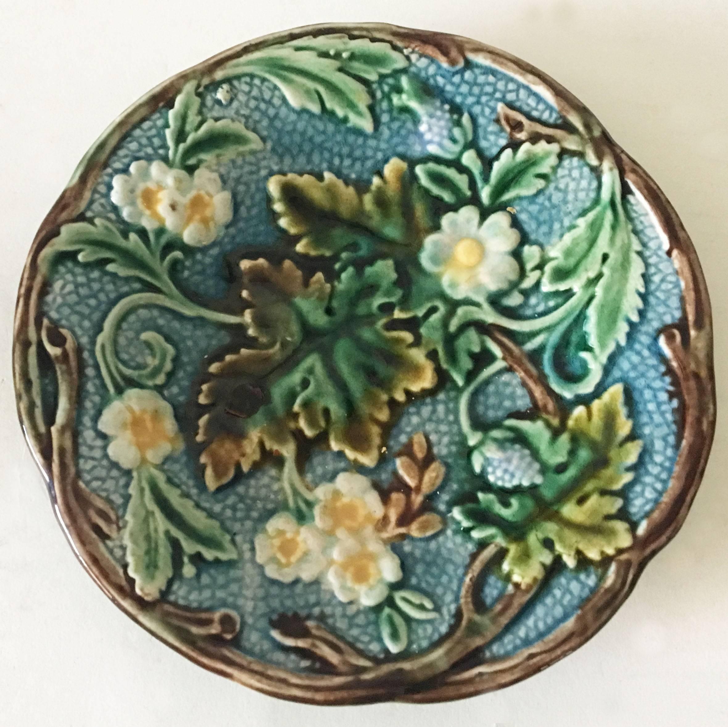 Swedish Majolica dessert plate signed Rörstrand, circa 1897. 
Decorated with white flowers and berries on a blue background, branches on the border.
7 plates available.