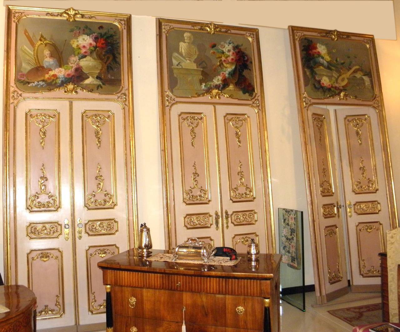 Series of four lacquered and gilded double doors made circa 1750, complete with frame and paintings on the top. The front has a very fine carved foliage in giltwood, the back is only lacquered and gilded with no carving. The four paintings, oil on