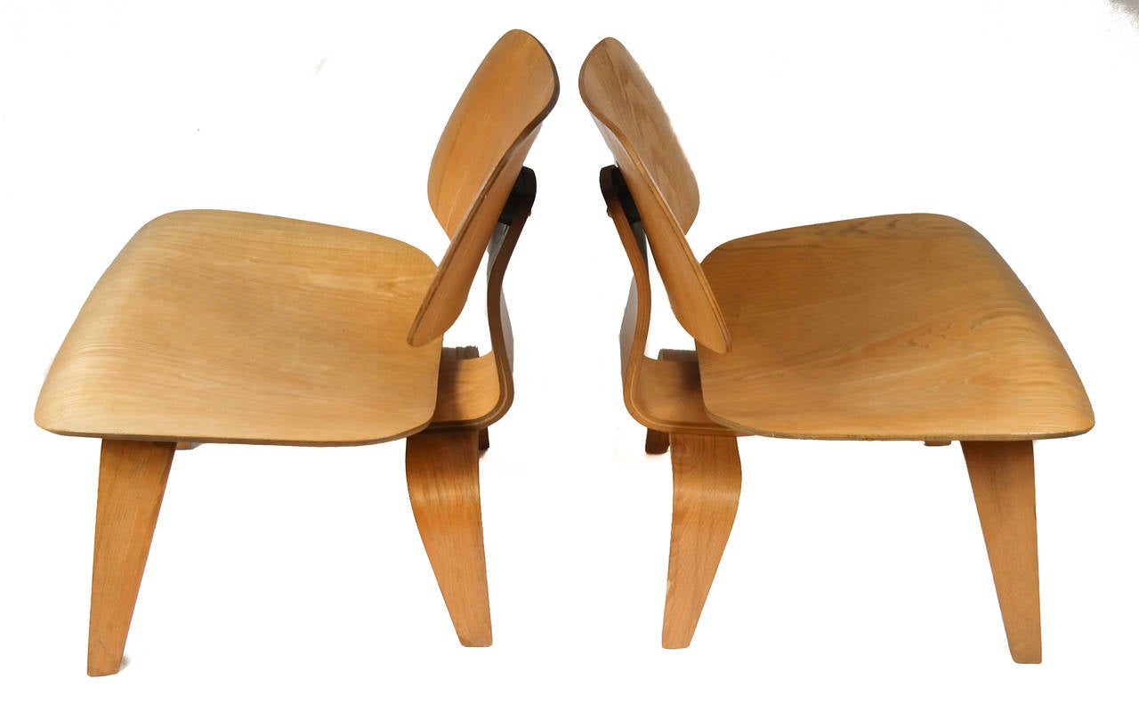 Pair of iconic early Charles Eames (1907-1978) LCW lounge chairs, with molded plywood back, seat and tapered supports, circa late 1940s.