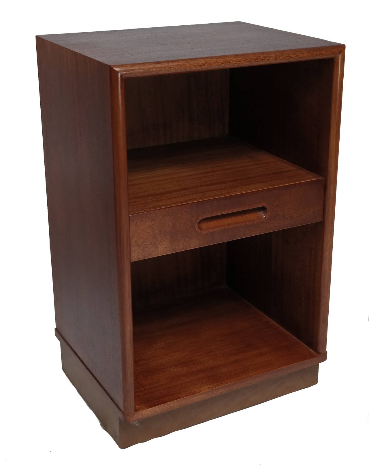 Pair of Dunbar bedside cabinets, designed by Edward Wormley (1907-1995), Mahogany with a central drawer between open shelves, raised on a leather faced plinth base. Tags in tact.