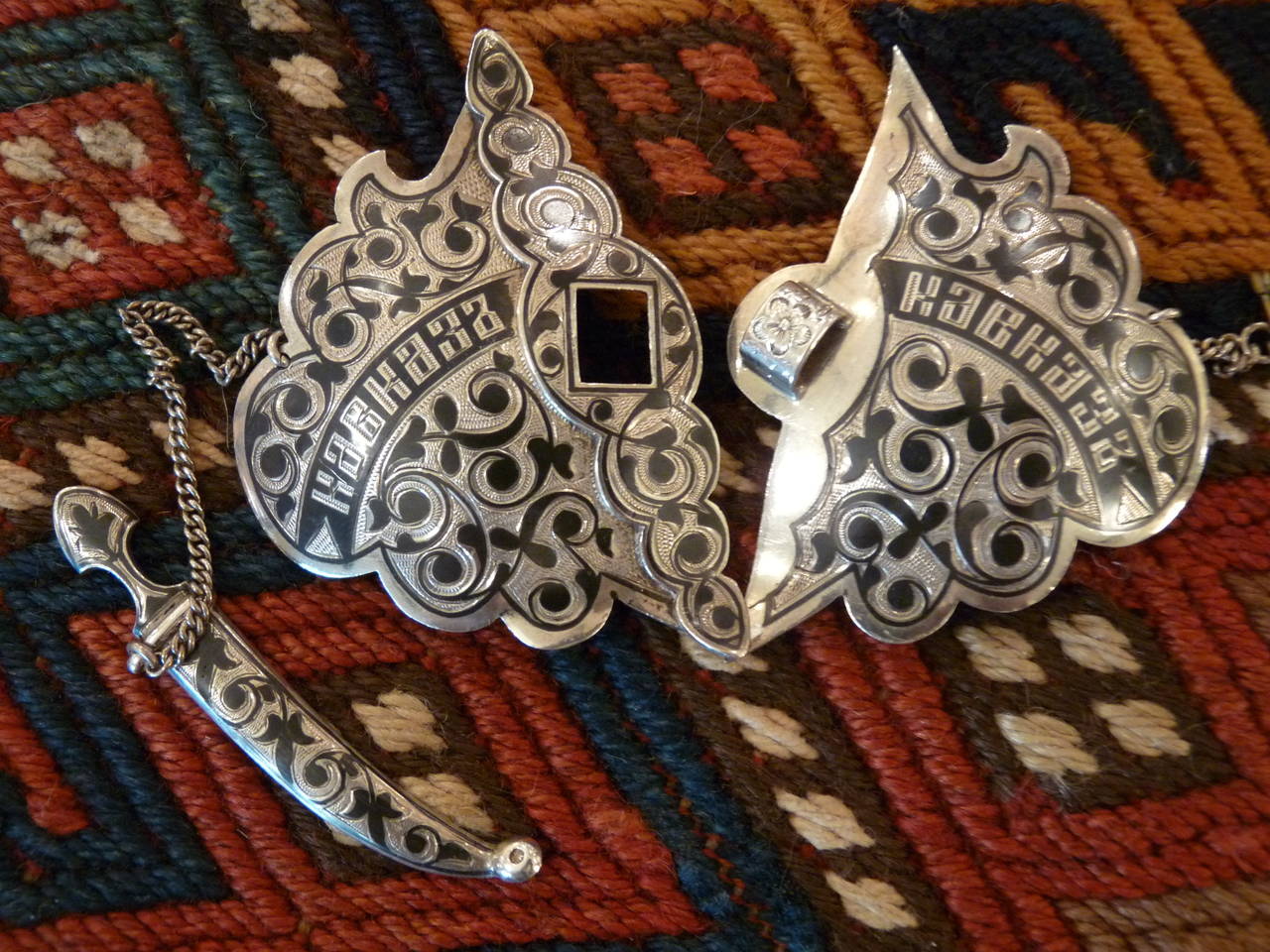 A beautiful and striking Russian silver cape buckle engraved and decorated with niello. 
Inscribed Kavkaz, which translates as 'from the Caucasus', which likely refers to a military campaign. The reverse bears a silver mark '84' (875/1000) and the