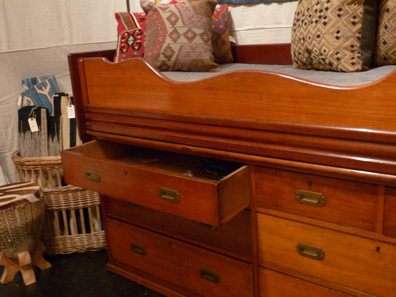 A functional ship's cabin bed is pre-Titanic and large enough to be used in a guest room, children's room or even modified into a serving piece.  It is crafted from teak and mahogany and has brass accents. A Stunning piece with beautiful lines and