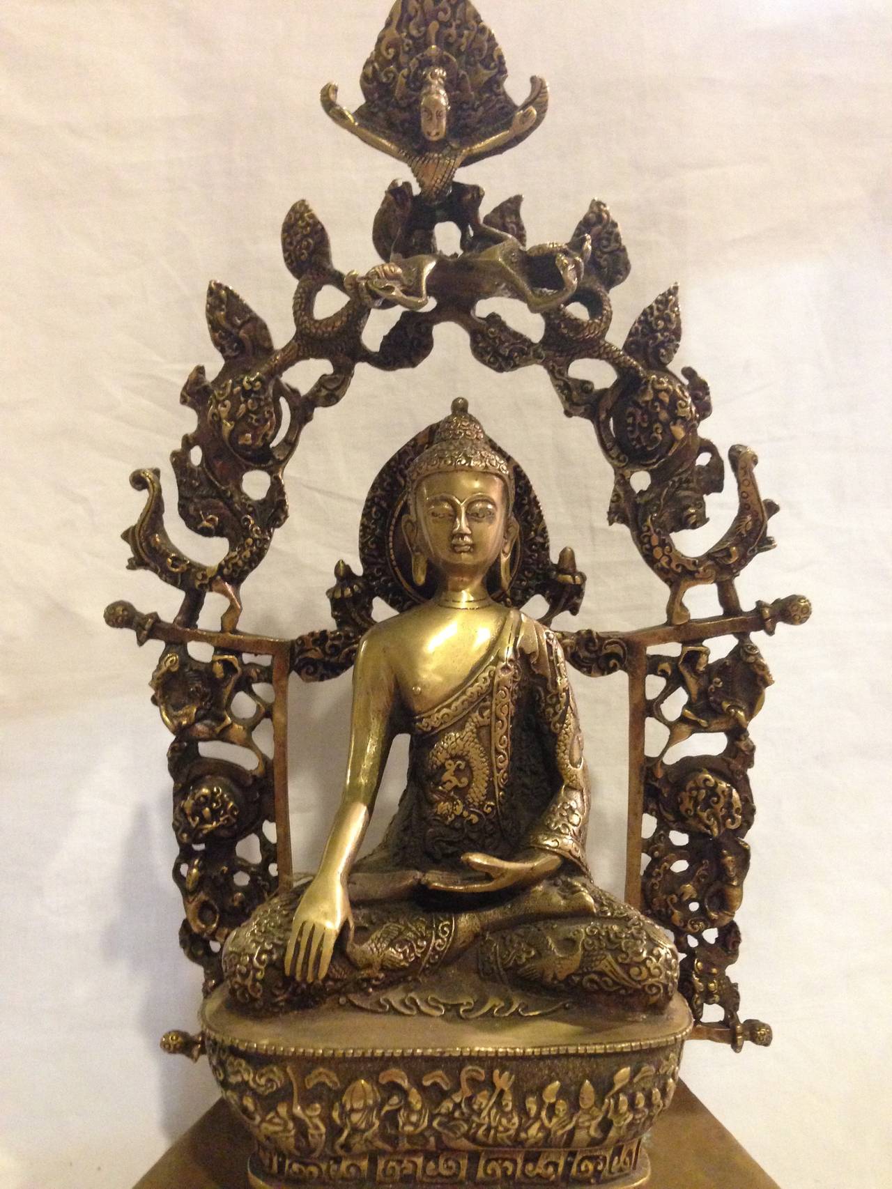 This amazing piece features Buddha in the exotic Silk Road Style. Consisting 3 separate components, each elaborately adorned, no details were overlooked. The main statue is seated on a fully decorated throne with griffins, lotus wheel, eternity