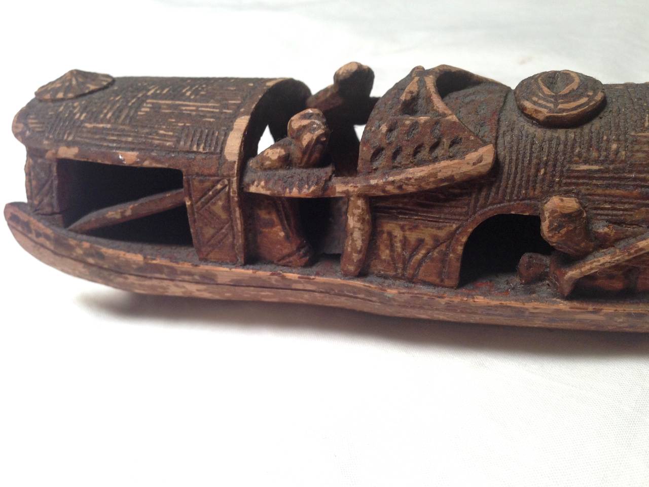 A charming, fine example of 19th century Chinese folk art. The material is one single piece of bamboo. 

The carver depicts two men, in scholar's attires, enjoying the view from the sides of the boat. The heads of these figures measure only 1/4