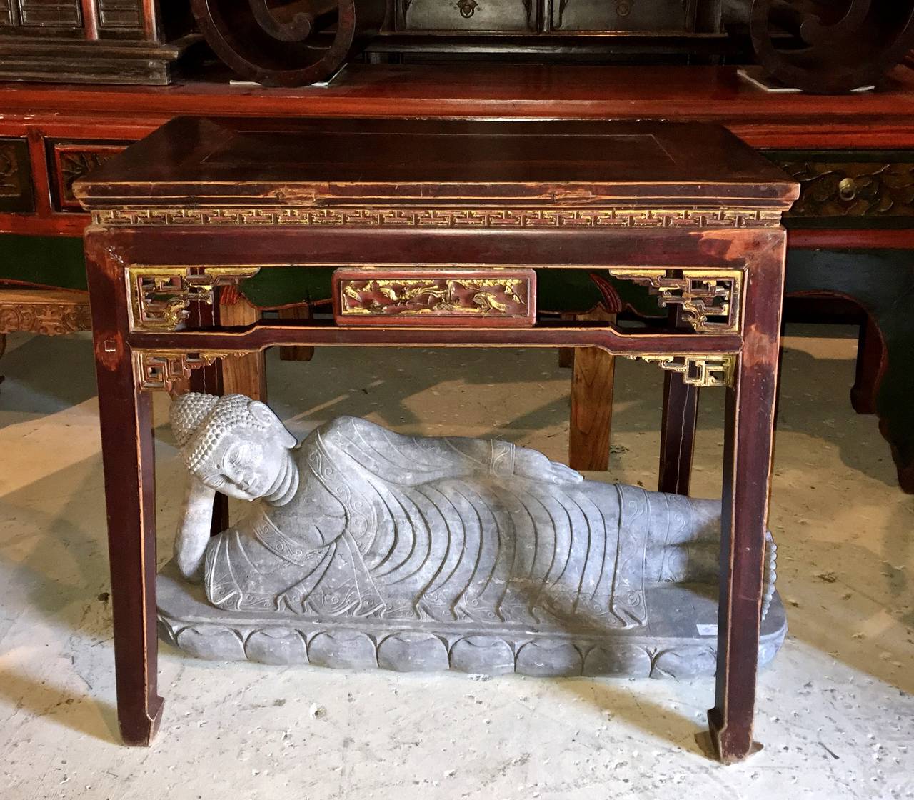 This is one of our most beautiful side tables. The overall color is a type of reddish brown that gives off a wonderful warmth. Gilded carvings add to its glamour while beautiful patina enhances its allure. Carved waist features the eternity scroll,
