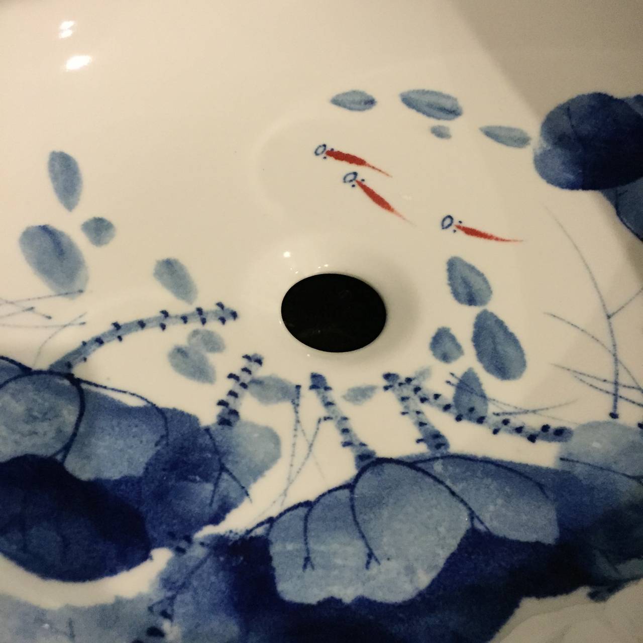This pair of beautiful sinks are the only pair that we have. Completely hand painted, the bowls depict groups of fish swimming amid lotuses. The use of inky blue is a classic Chinese watercolor approach. Details such as folds of the leaves, shrimps,