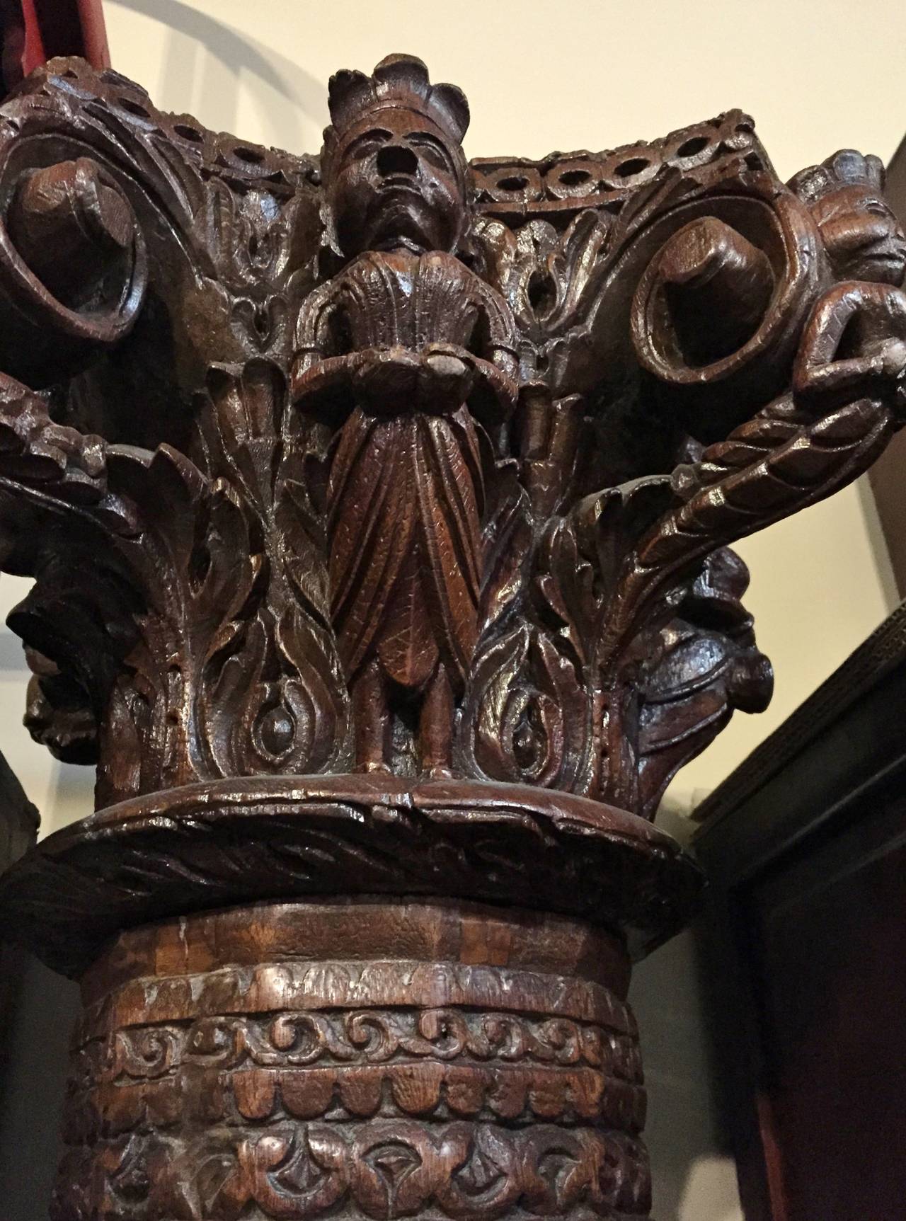 This extraordinary column has its original granite base, is made out of solid teak wood featuring an elaborately carved crown. The crown is carved on all four sides with each side featuring a different musician. Beautiful scroll works and foliage is