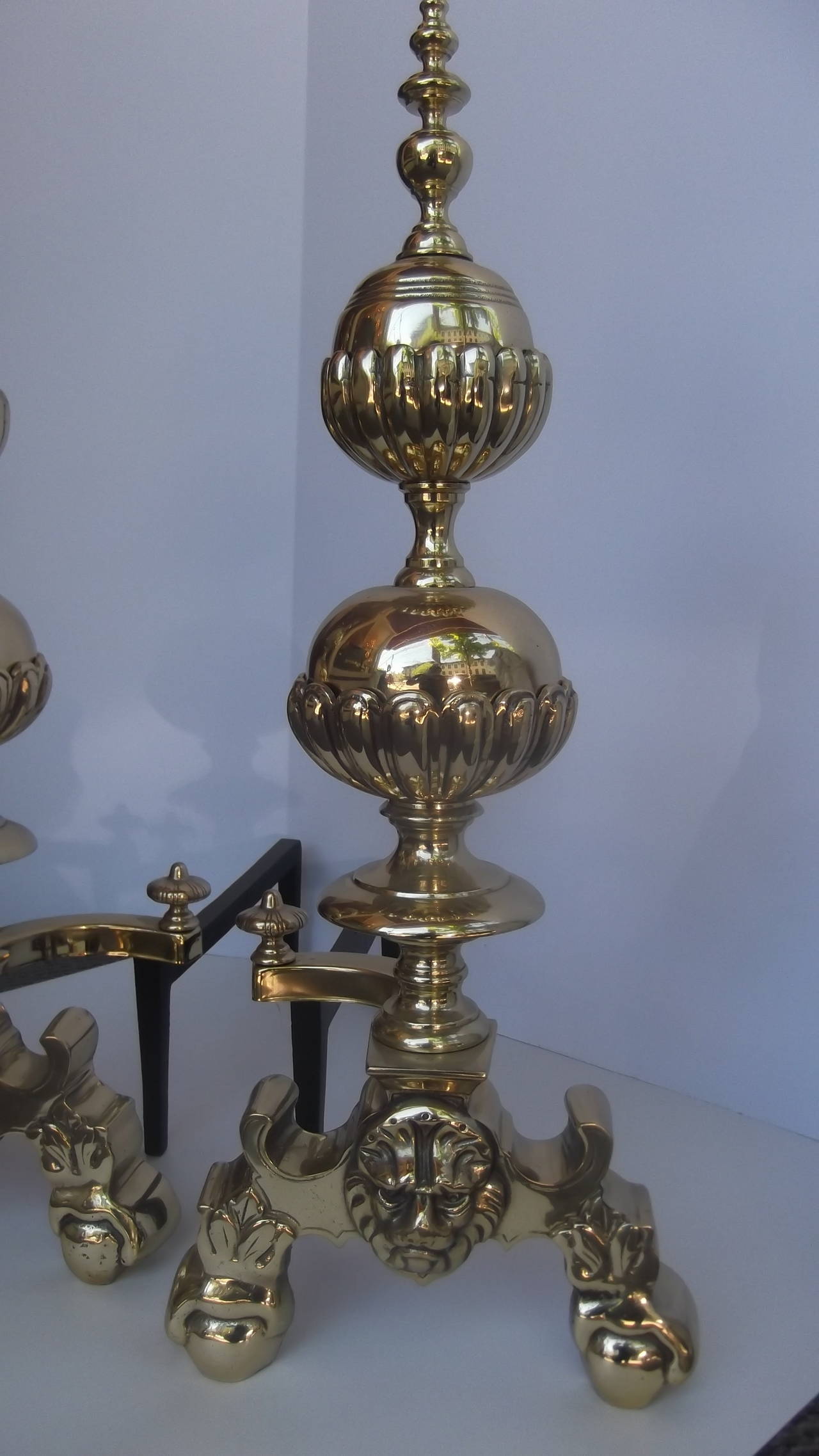 Magnificent pair of polished circa early 1900's solid brass andirons
Classic two graduated decorated spheres and spiral finial resting on lion head ball and claw feet.  The shanks are cast iron. Newly polished and lacquered.