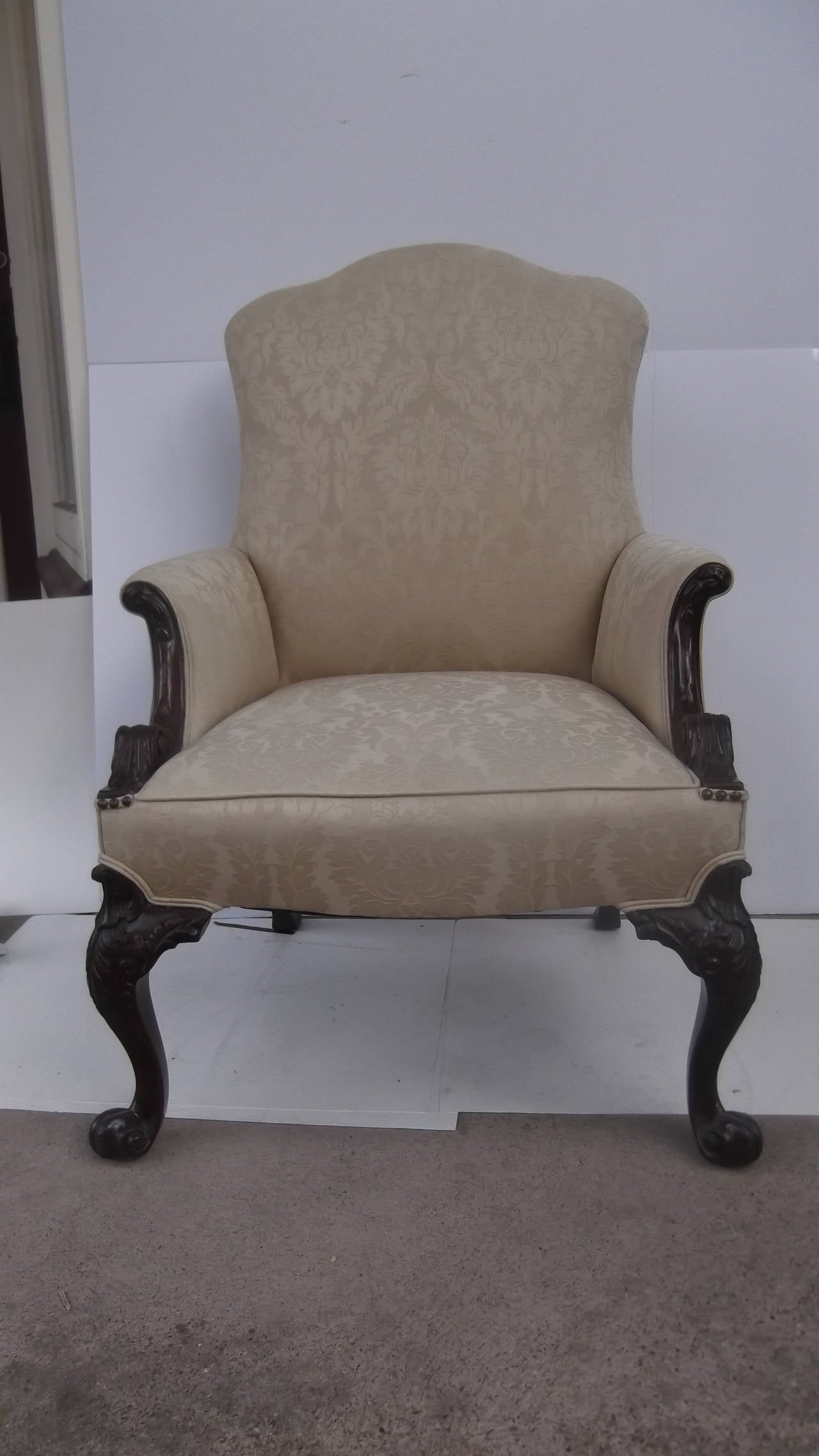 A handsome Georgian style library chair.
Beautifully carved solid mahogany legs with carved details on the arms.
The fabric is a woven damask pattern, recent upholstery but can easily be changed to suit the next owners needs.  Very sturdy hardwood