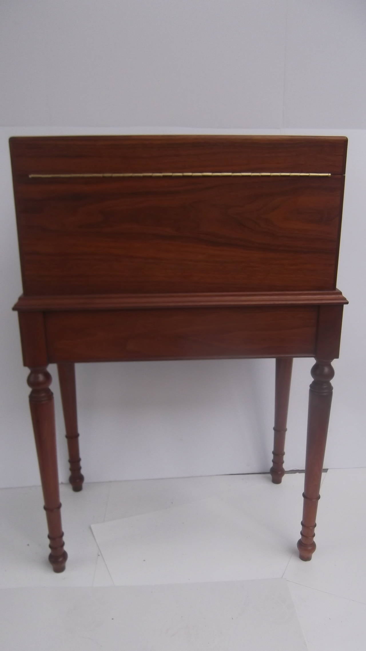 A handsome medium stained mahogany humidor from the 1930-1940's.  Designed as a 19th century box on stand, this piece of accent furniture is a functional humidor. The humidor box is tin lined, has a plaque noting 