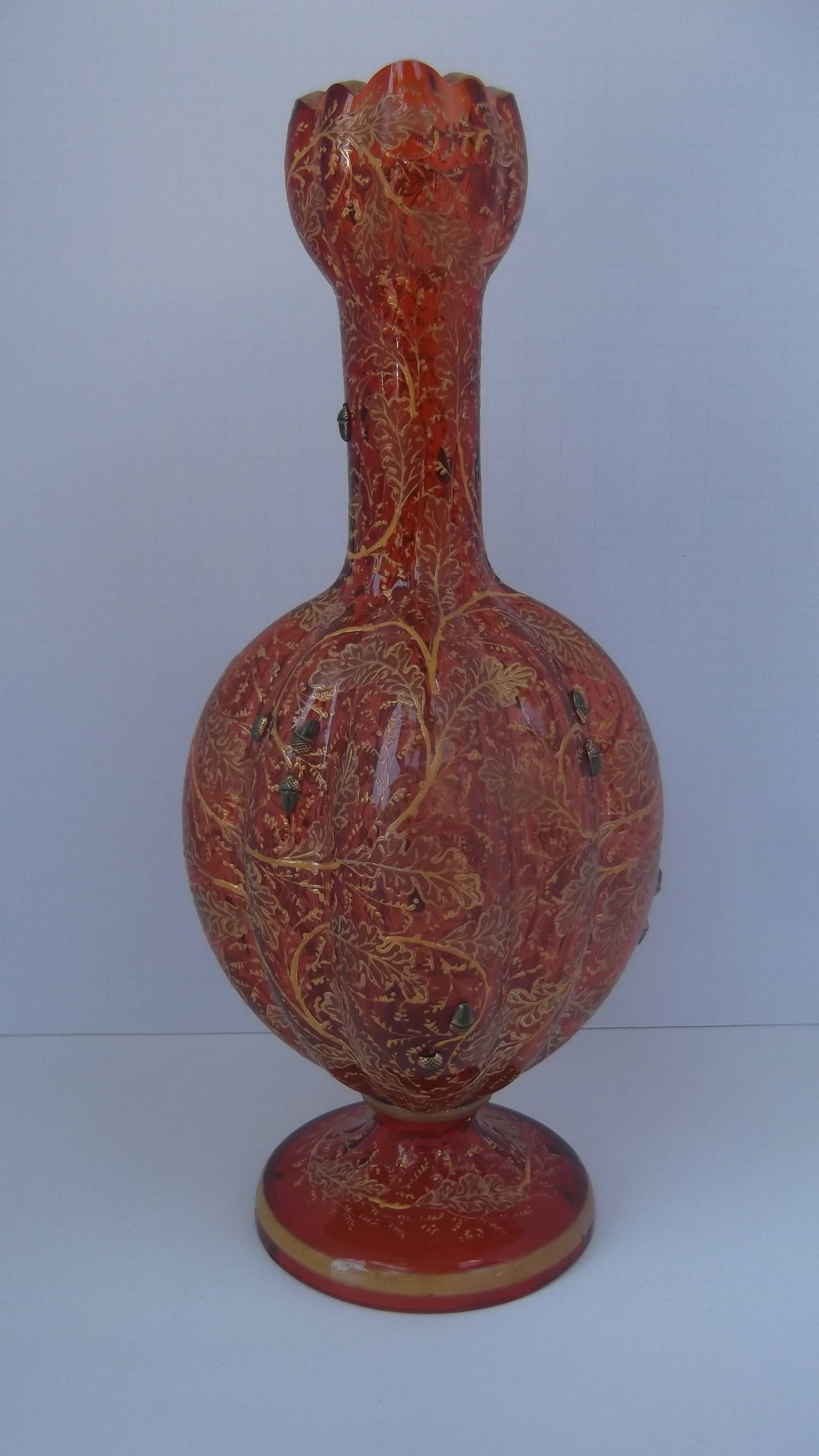Intricate Moser enameled vase with oak leaves with small and very detailed acorns.  Lovely ruby hand blown glass in a gourd form with scalloped top, bulbous middle and circular pedestal base. The all over enamel decoration is applied by hand.