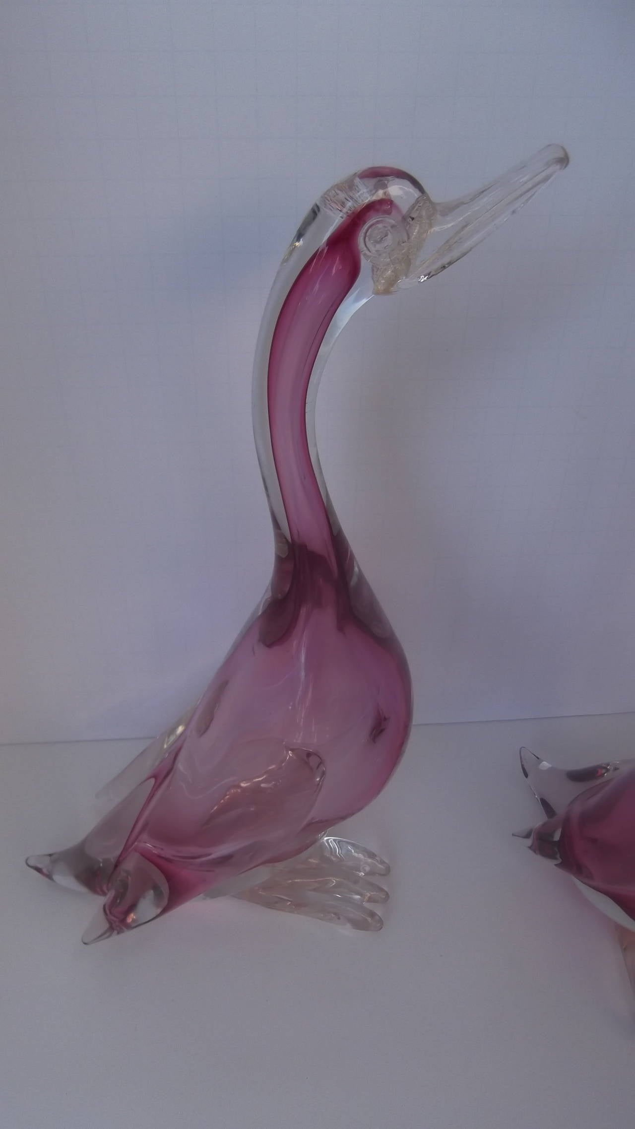 Whimsical pair of handblown Murano sommerso glass by Alfredo Barbini. The bodies are magenta with a heavy clear outer glass. The beaks and feet have gold fleck, classic to fine Murano glass.

Alfredo Barbini, a glass artist born in 1912 on the