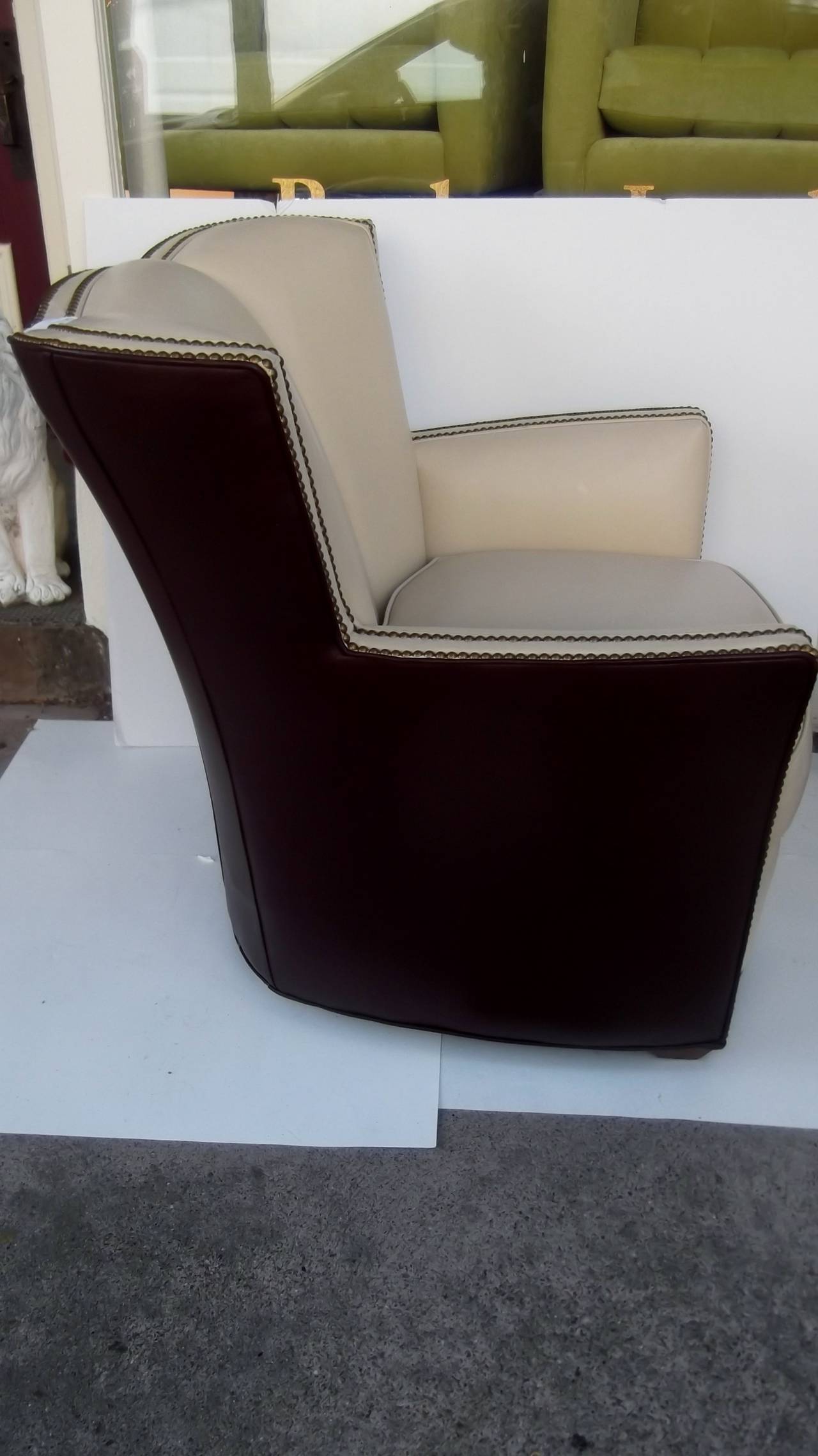 100% high quality leather chairs made by Hancock and Moore, this frame is now retired.  The vanilla lather interior is offset with a double row of aged brass nail head trim with faired back and arms.  The outside is covered in luscious deep eggplant