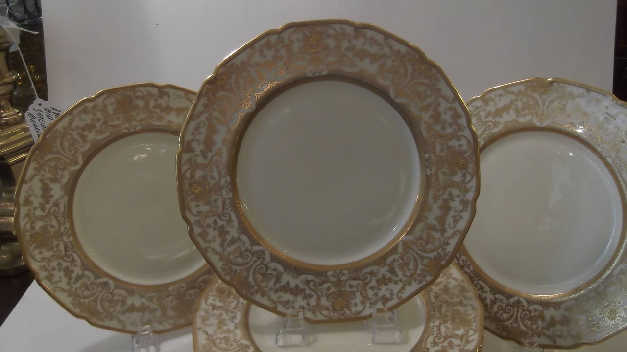 A Set of 12 Tiffany Service Plates.
Made by the Royal Doulton company in England,  by the principal decorator, Herbert Betteley.  These plates are a simple ivory china with elaborate raised gilt borders. Dinner Plate size 10