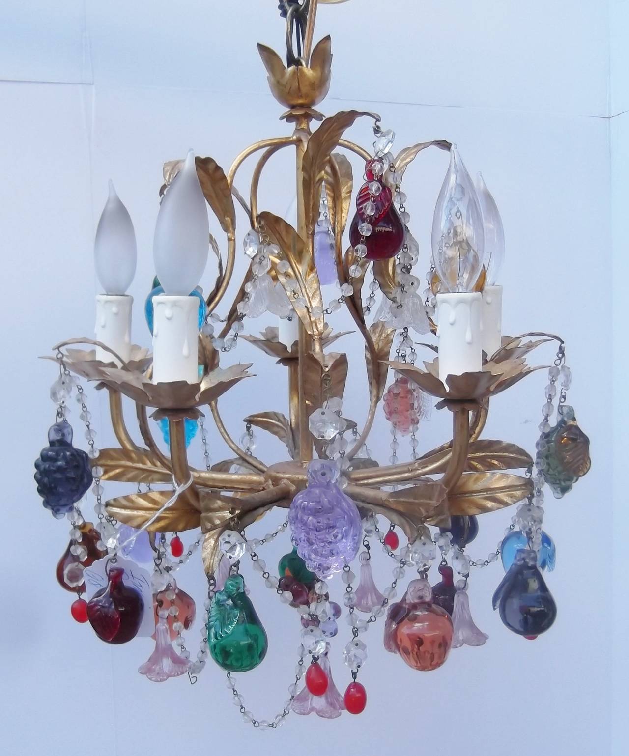 Playful and colorful Italian chandelier with multi colored hand crafted Italian glass fruit and faceted glass beading.  The gilt metal frame is adorned with leaf decoration supported by a center bar. This chandelier is an unusual alternative to the