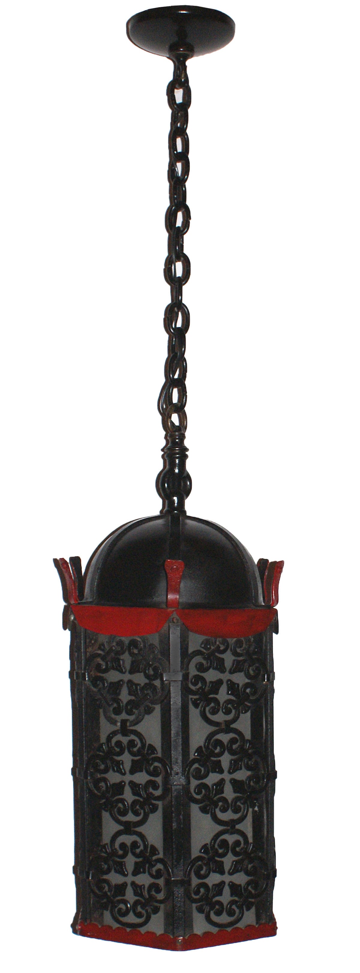 Spanish Gothic style cast-iron hexagonal form pendant lantern having domed top and ornamental metalwork frame with Fleur De Lis and quatrefoil motifs over frosted glass panels, circa 1920. A finely done pierced design adorns the underside of the