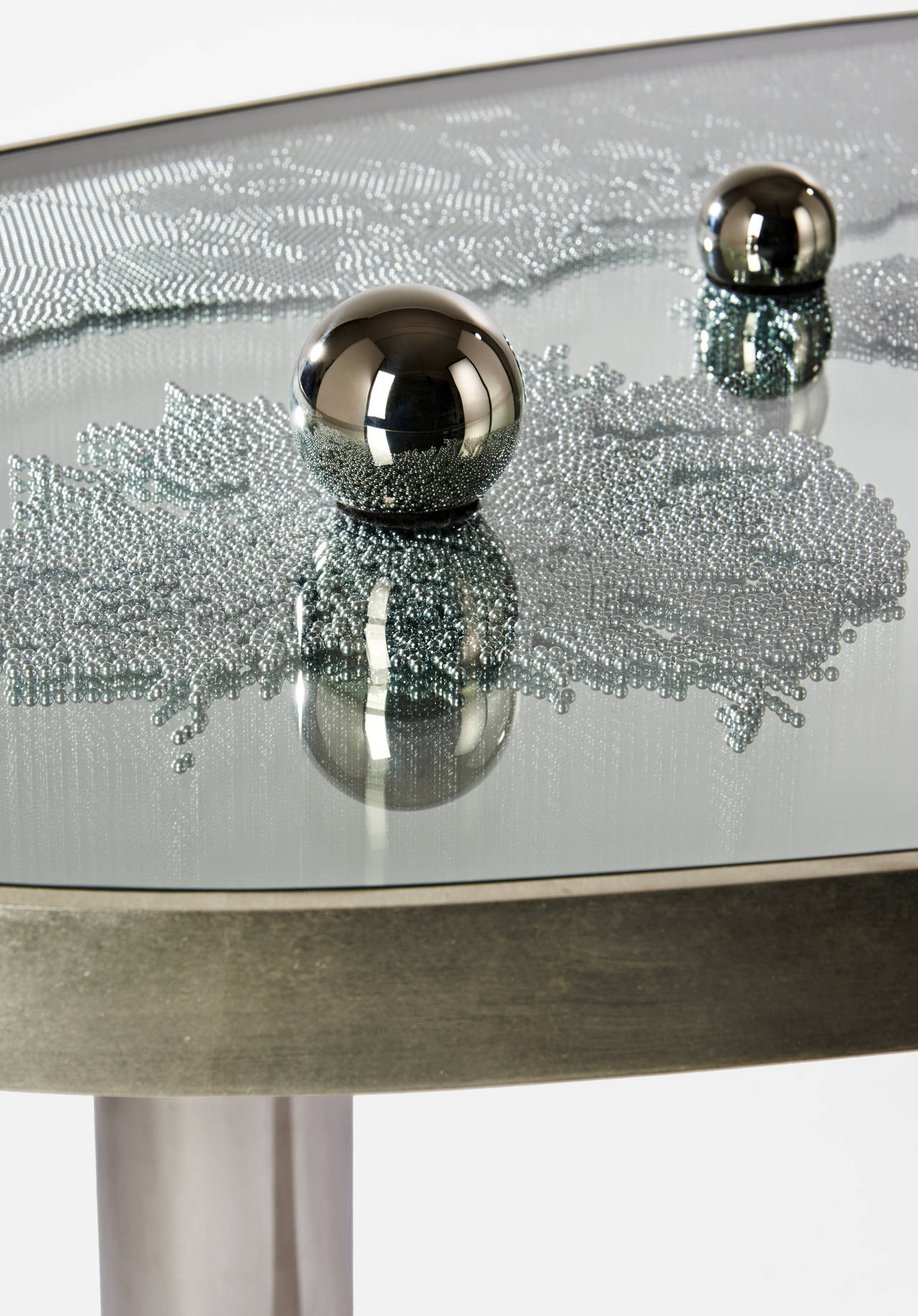 Table in bronze covered with white gold leaves and steel balls.
On the top of the glass tray there are 2 magnets to attract the balls and change the table's aesthetic.
Edition of eight.
Signed and numbered.

Hubert le Gall was born in Lyon in