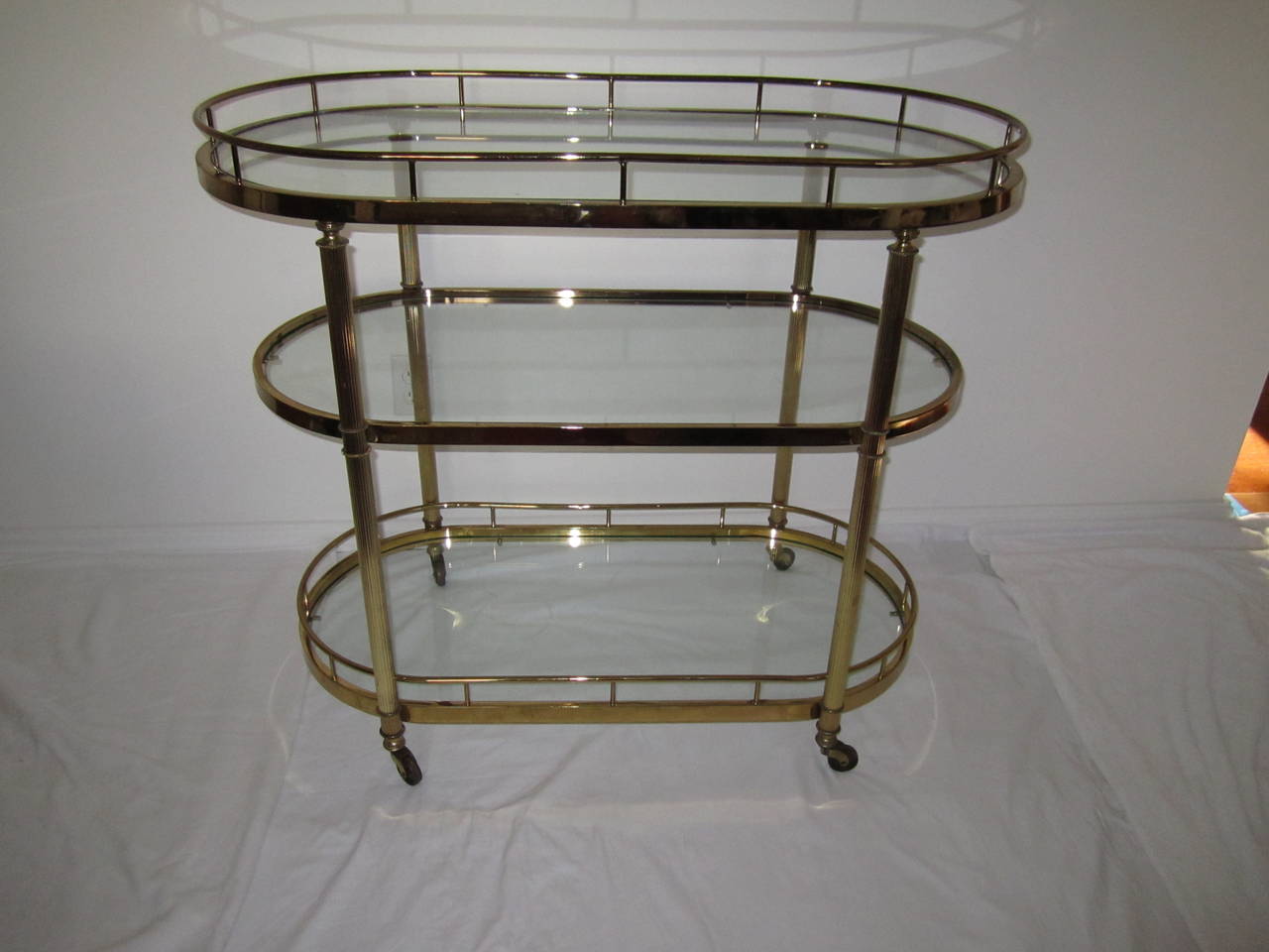 Vintage oval brass bar cart designed for the Design Institute of America (D.I.A.).

Solidly built vintage polished brass and glass bar cart designed for DIA, Design Institute of America. Set on rolling casters with three oval