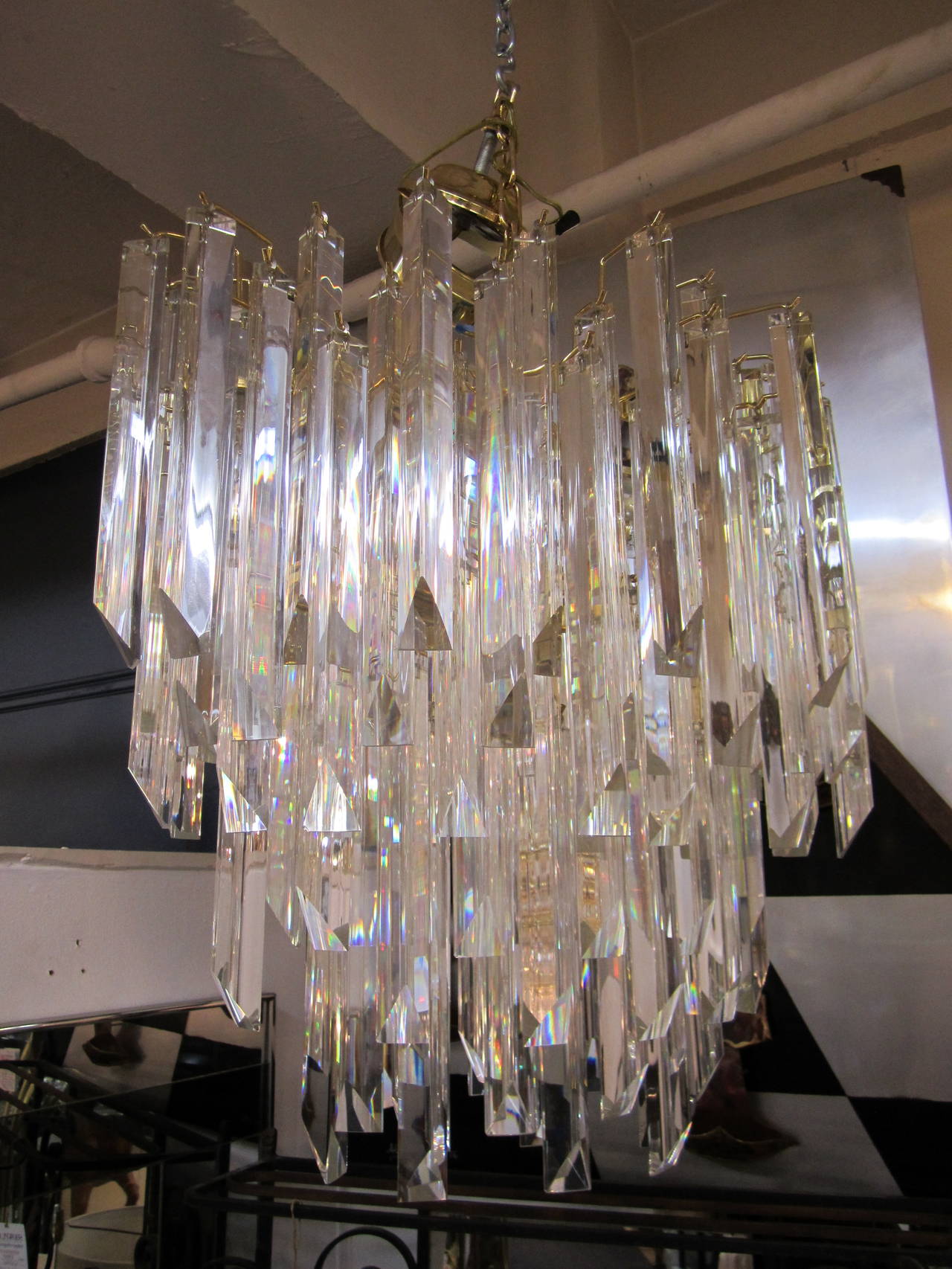 Stunning and substantial Modern style crystal chandelier with a brass-plated frame, in the style of Venini, circa late-20th century. Frame is marque or oval in shape. Crystals are triangular in shape and are 11