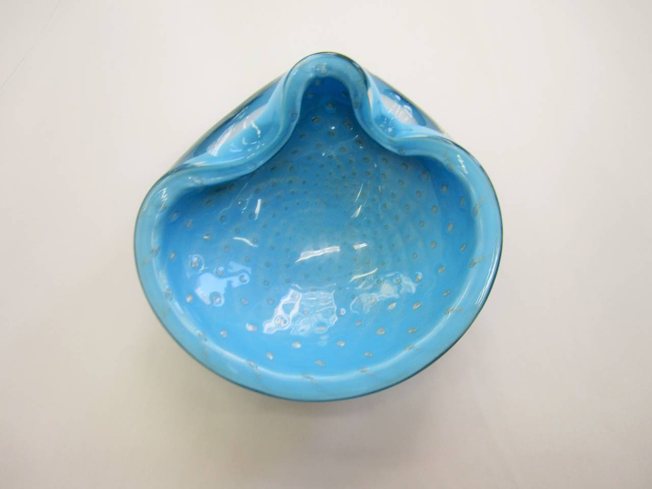 A beautiful and substantial Mid-20th century Italian Murano art glass bowl in powder blue with controlled bubble and silver fleck design, after designer Alfredo Barbini, circa 1960s, Italy. 

Measures: 5