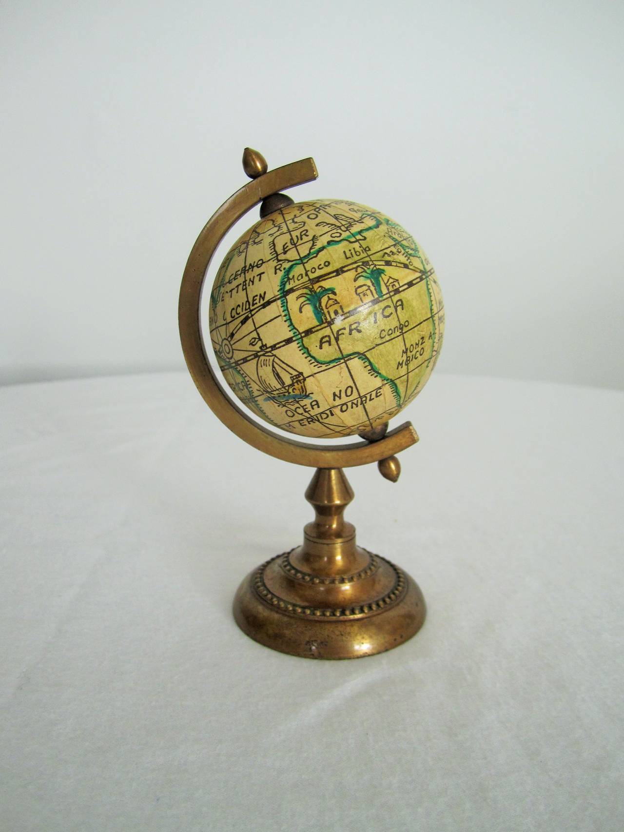 An Italian vintage mini world globe that spins. Hardware of brass. Marked 