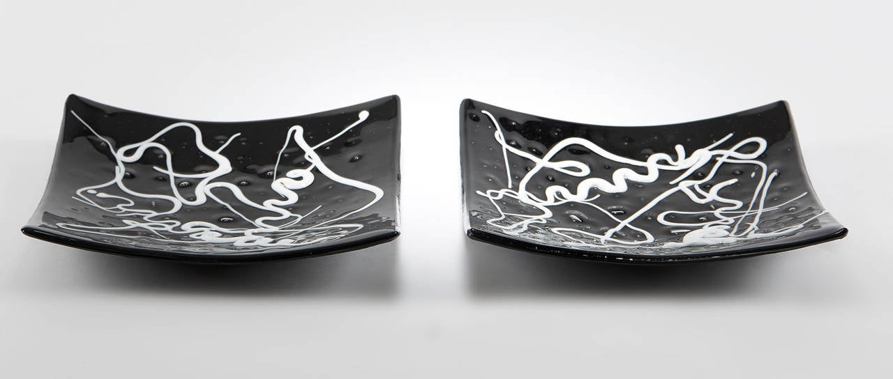 Pair Murano handblown art glass dishes by Cose Belle Cose Rare black clear cased dishes of square shape with raised edges the body with raised bubble surface with the black ground applied with abstract trailed white glass designs. The textured bases